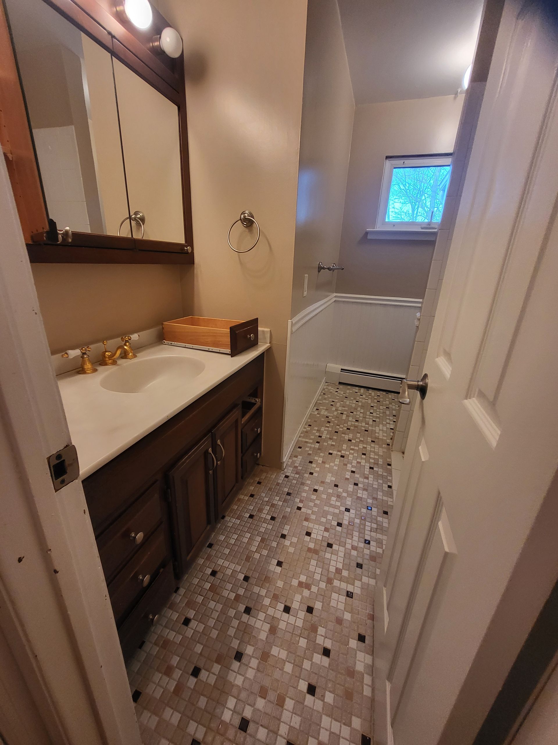 a bathroom with a sink, mirror, and tub