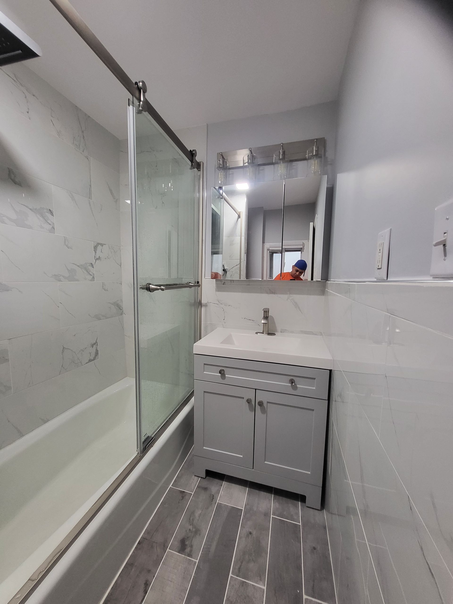 a bathroom with a sink, tub, shower, and mirror