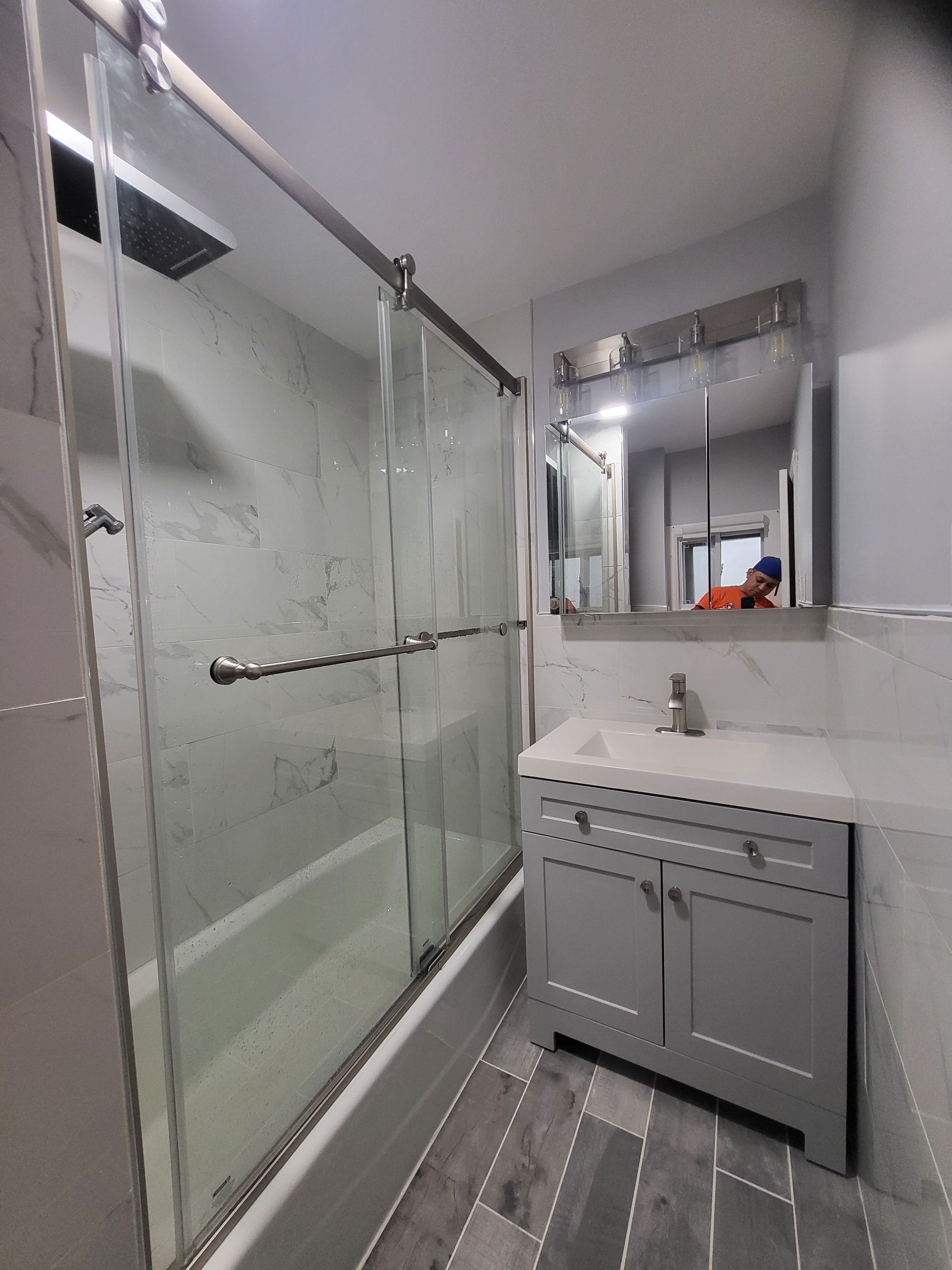 a bathroom with a sliding glass shower door and a sink