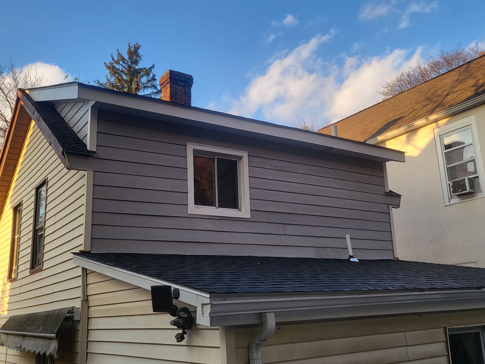 a house with a chimney on the roof and a window on the side