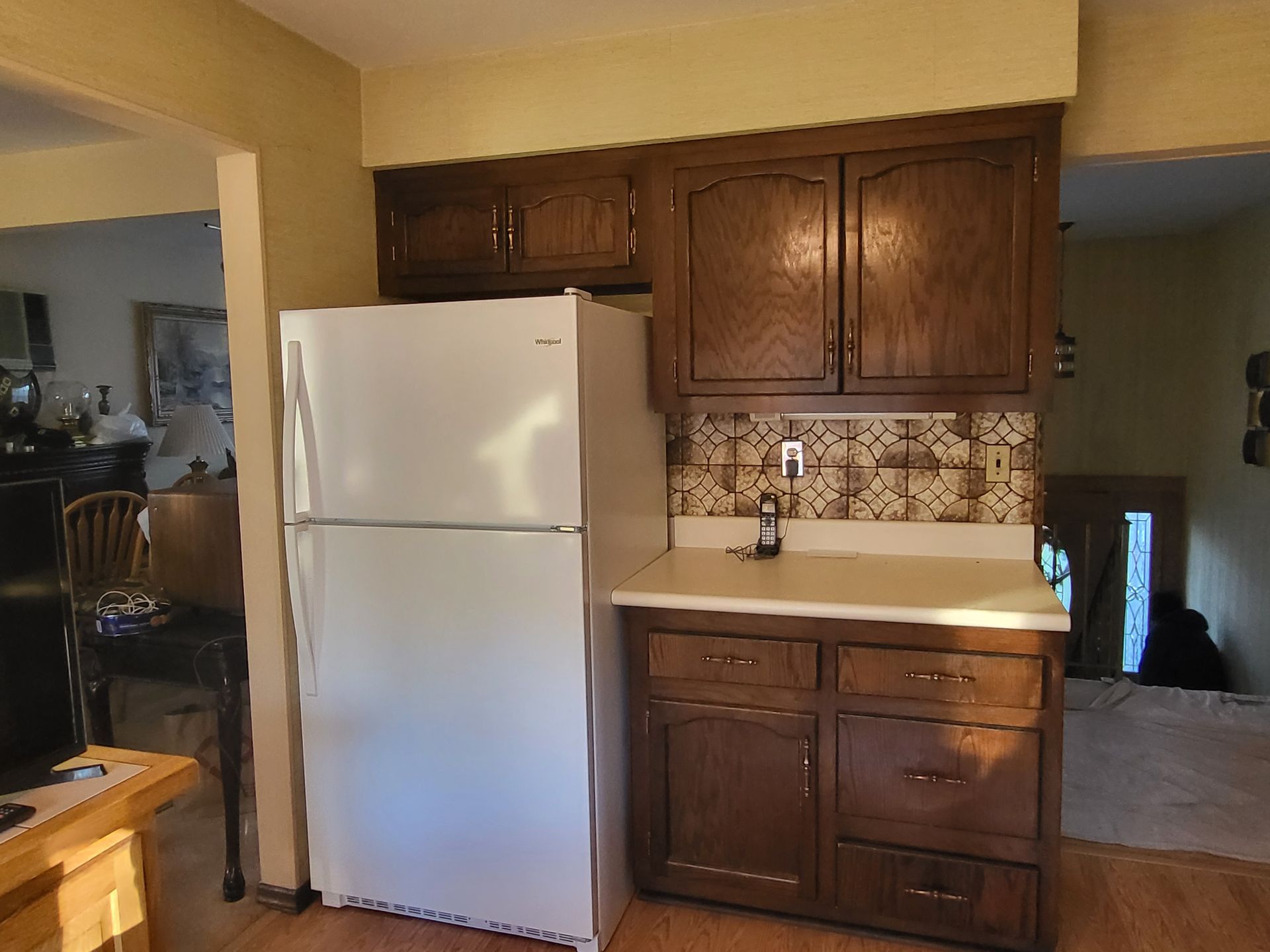 a kitchen with a white refrigerator and wooden cabinets