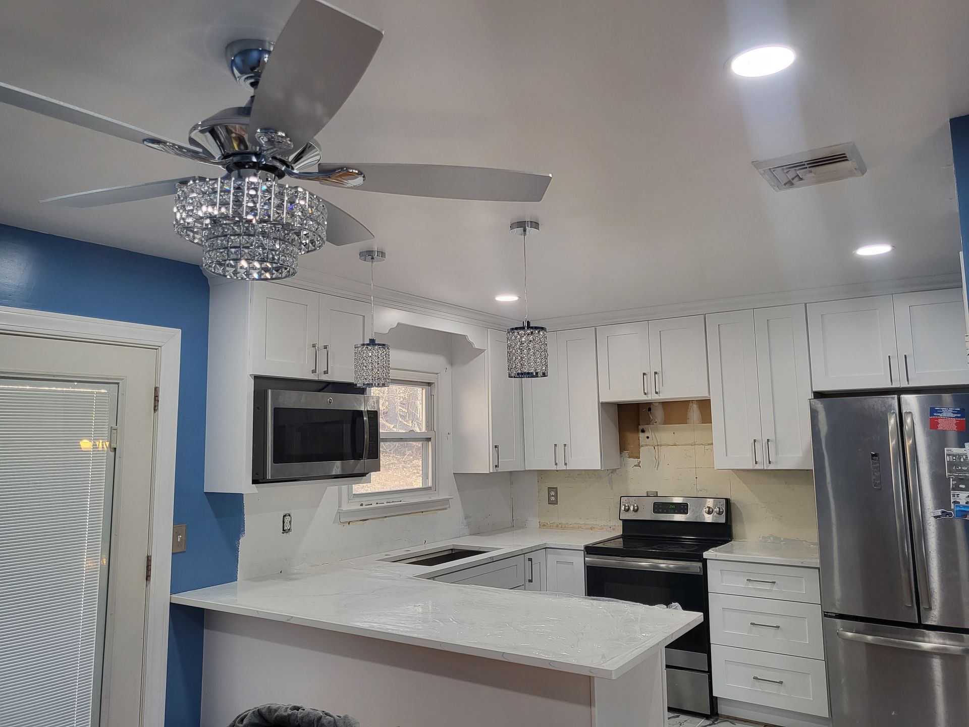 a kitchen with white cabinets and a ceiling fan