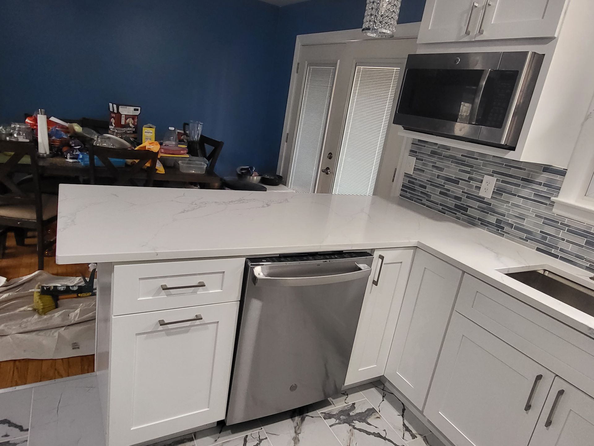 a kitchen with white cabinets and a stainless steel dishwasher
