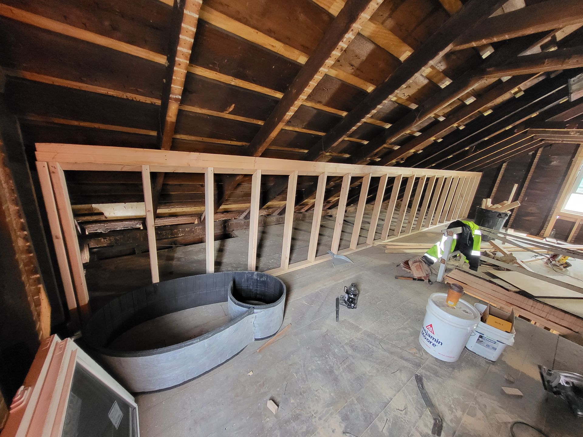 a man is working on a wooden structure in an attic