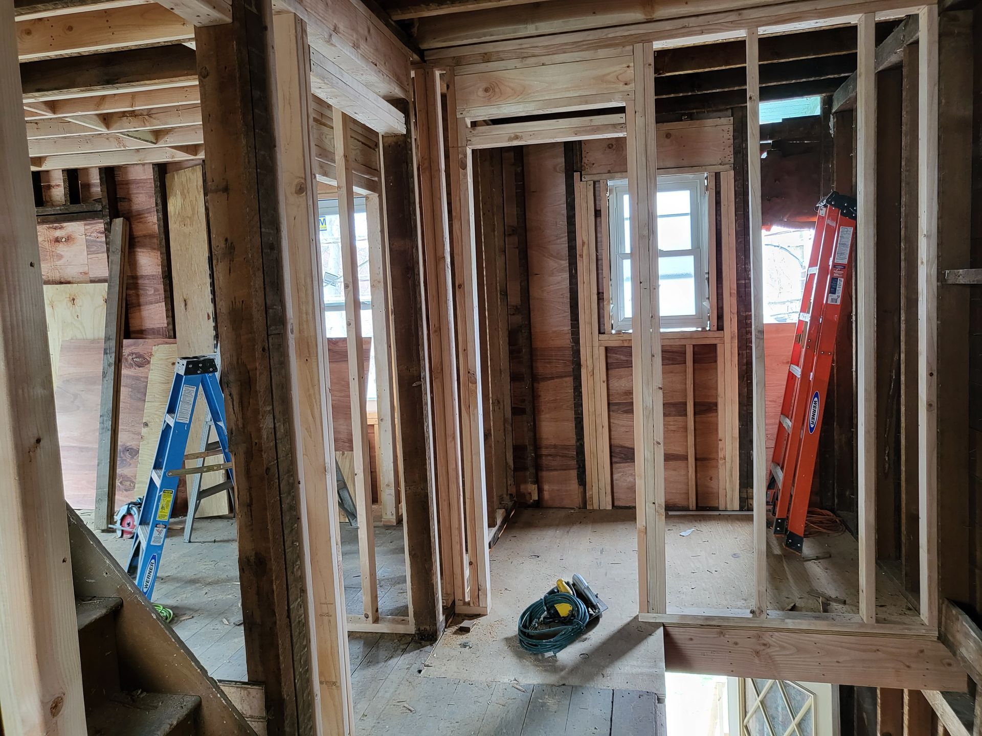 a room in a house under construction with a ladder and stairs