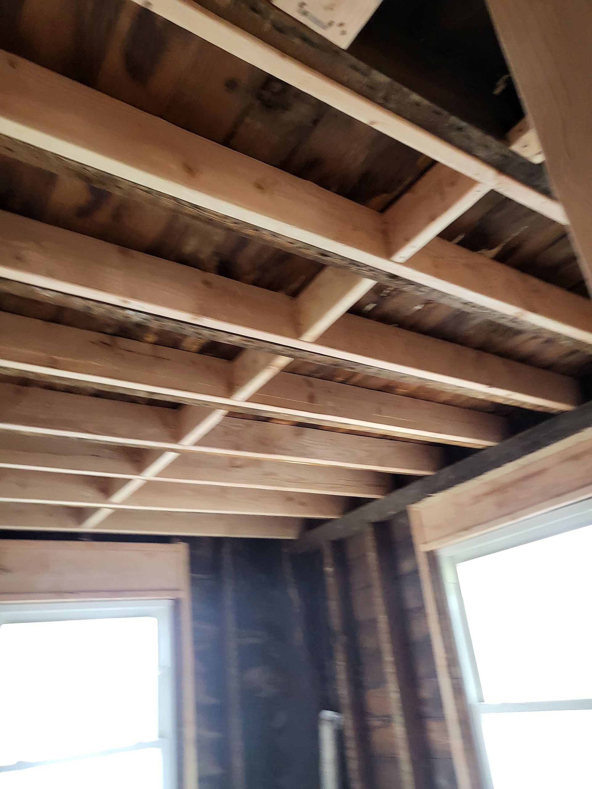 a room with a wooden ceiling and a window