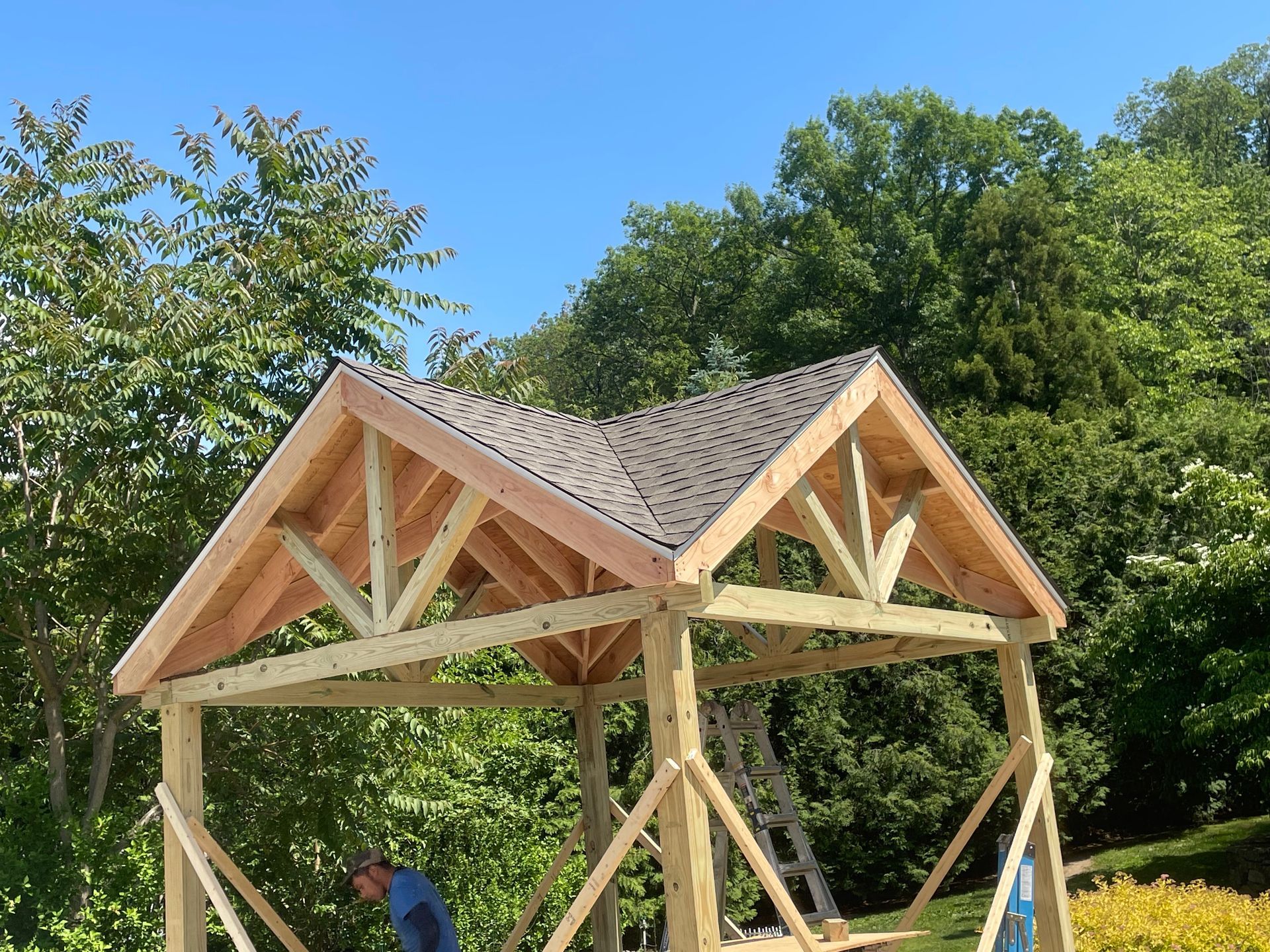 a man is working on a wooden structure with a roof