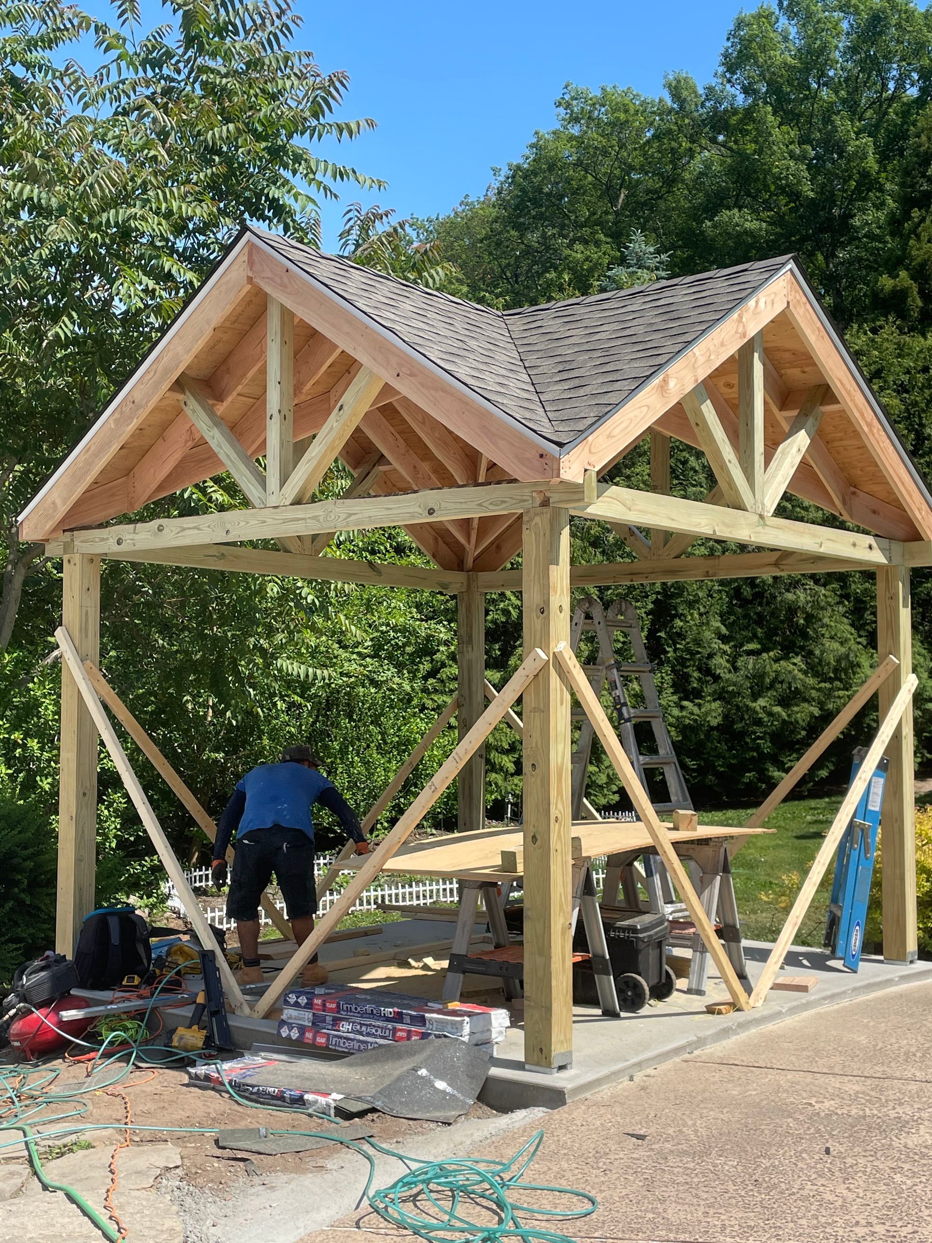 a man is working on a wooden structure with a roof