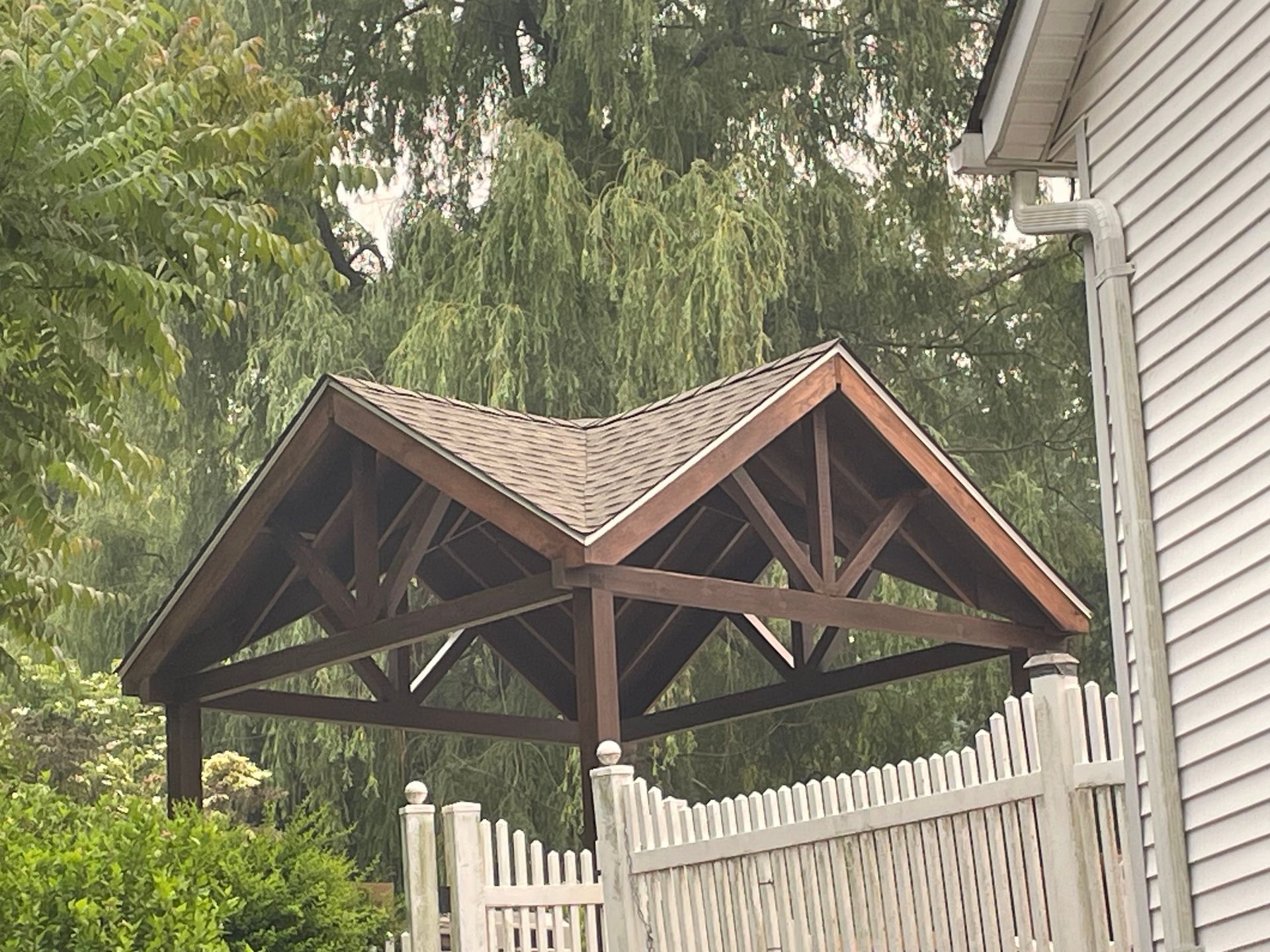 a white house with a wooden roof and a white picket fence