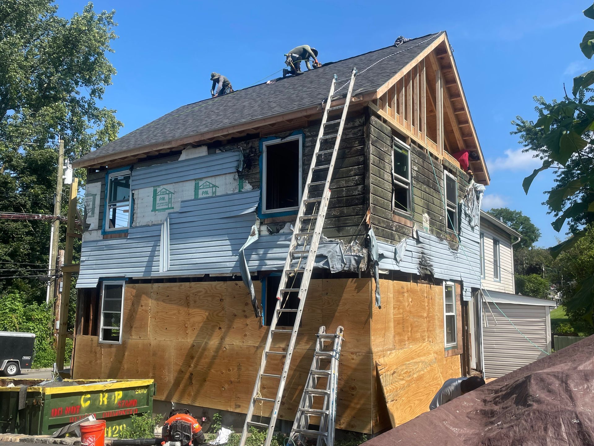 a group of people are working on the roof of a house