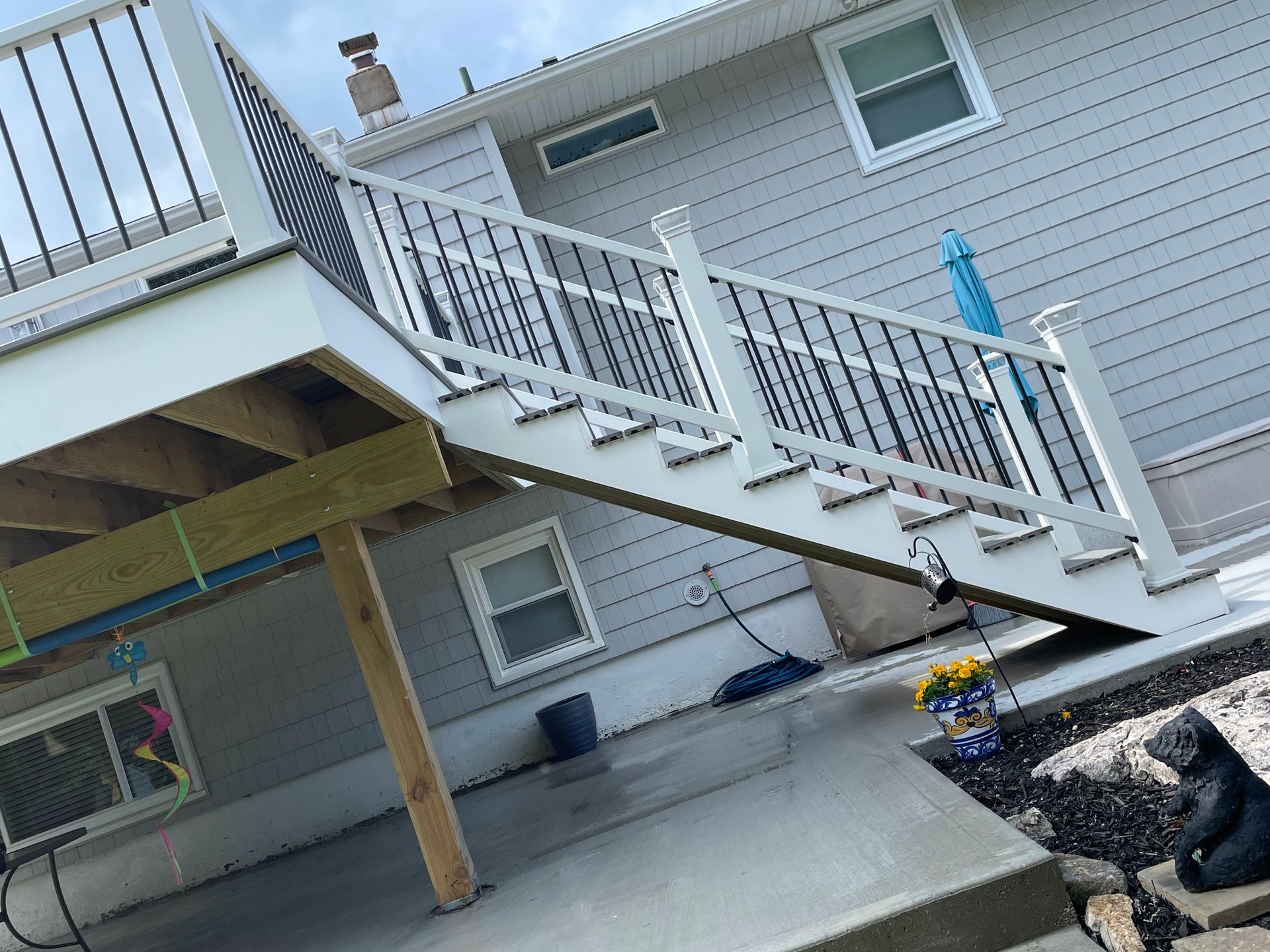 a white deck with stairs leading up to a house