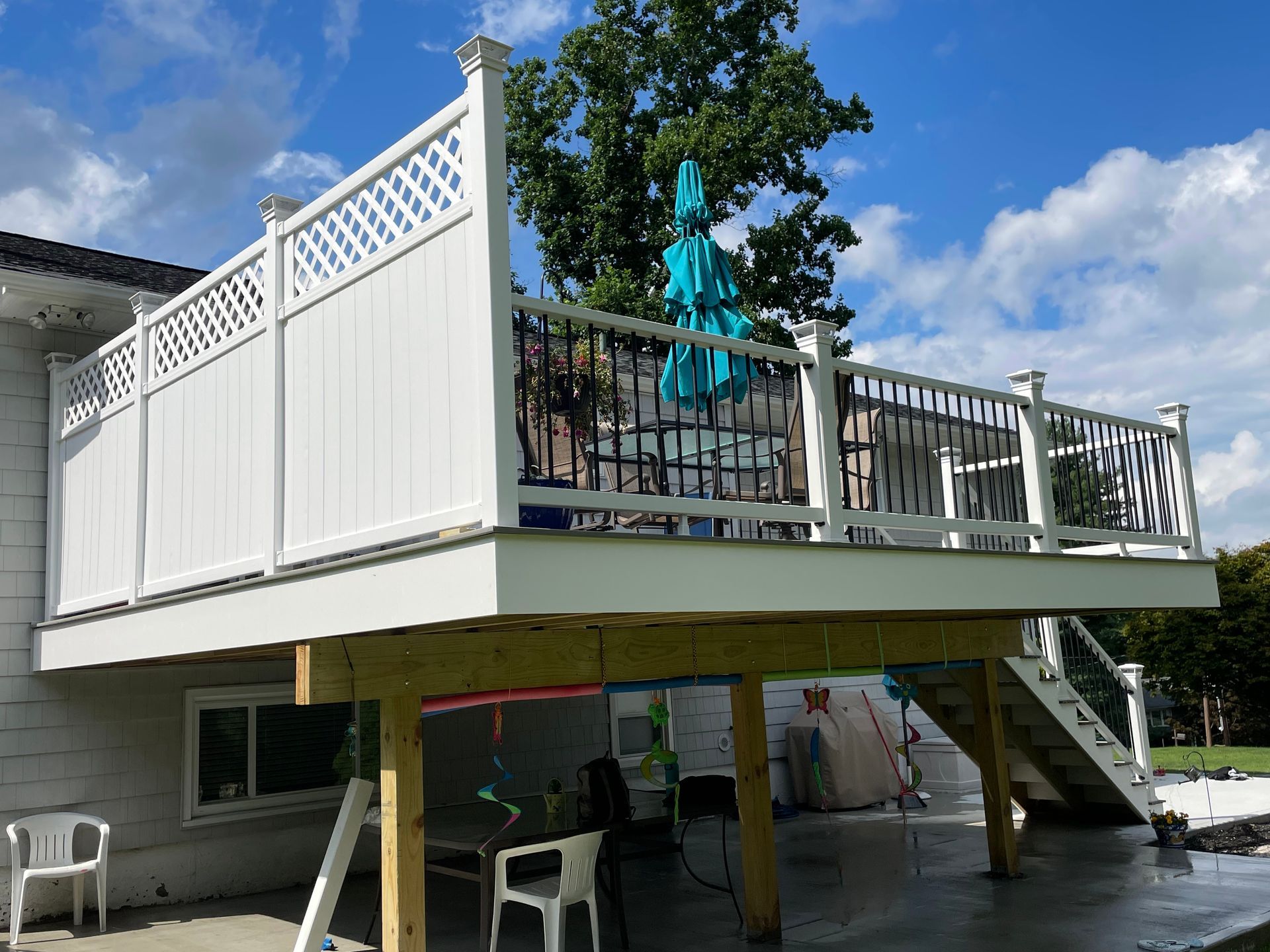 a white deck with a blue umbrella on top of it
