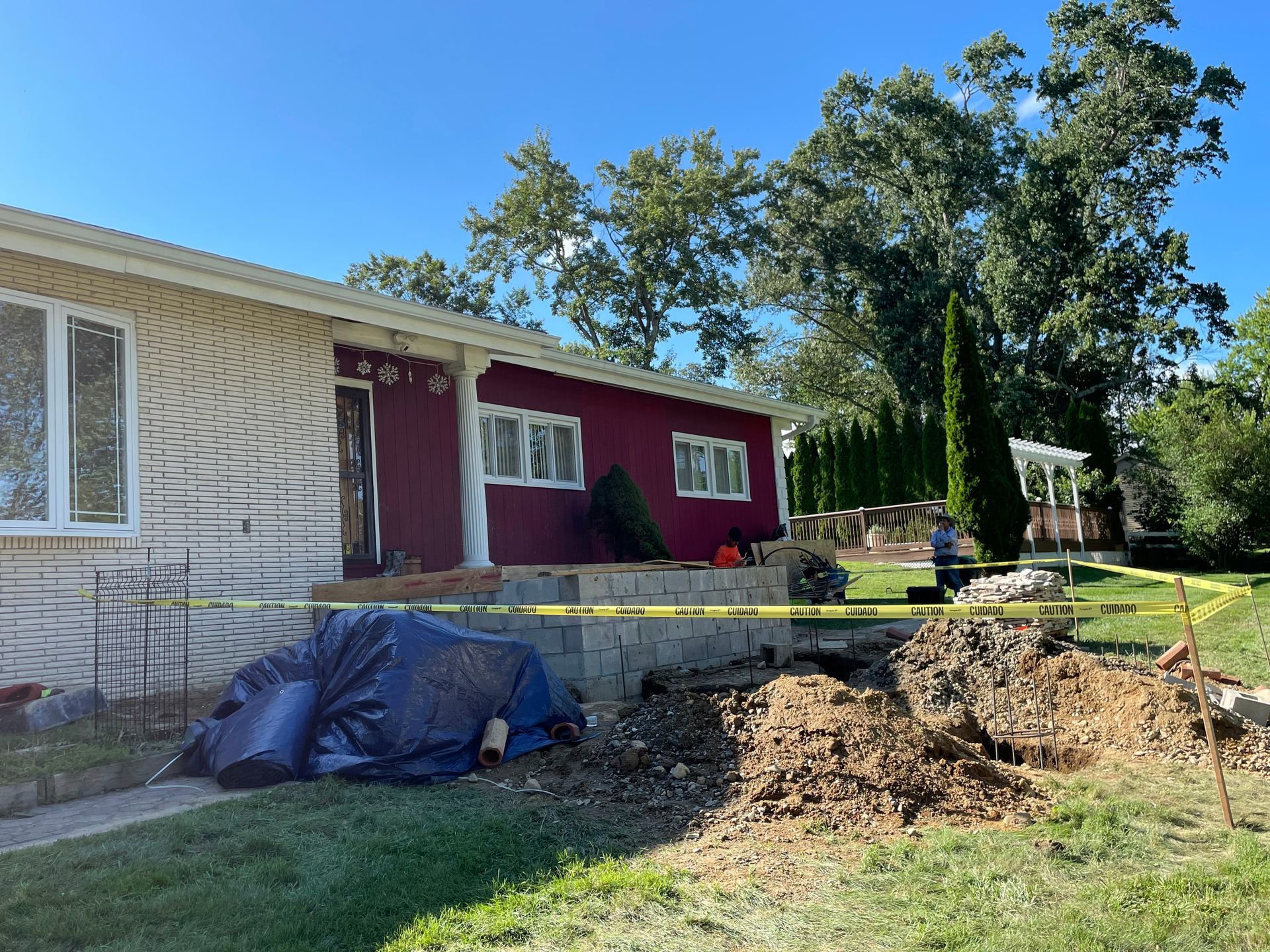 a white house with a red roof is surrounded by a yellow tape