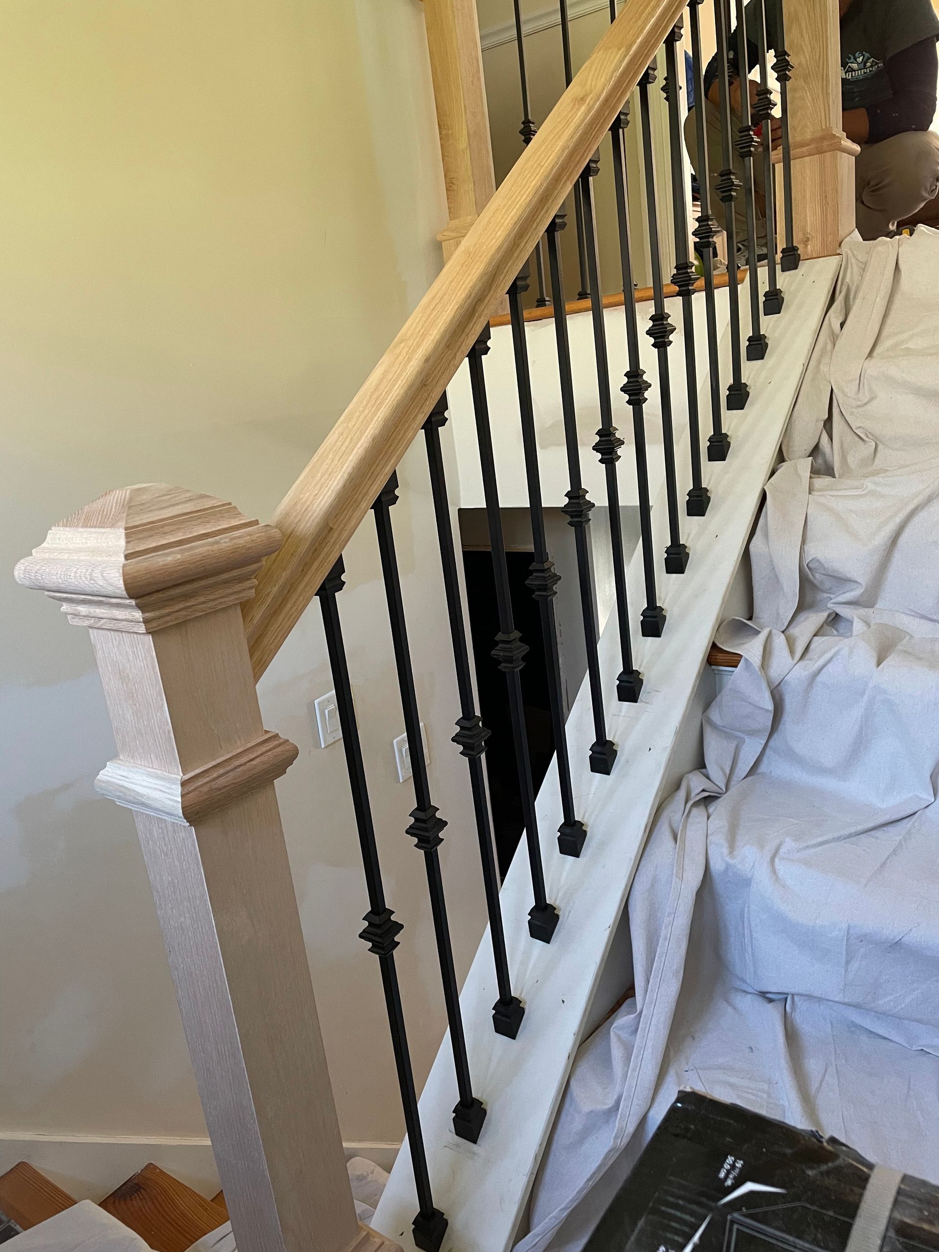 a staircase with a wooden railing is being painted