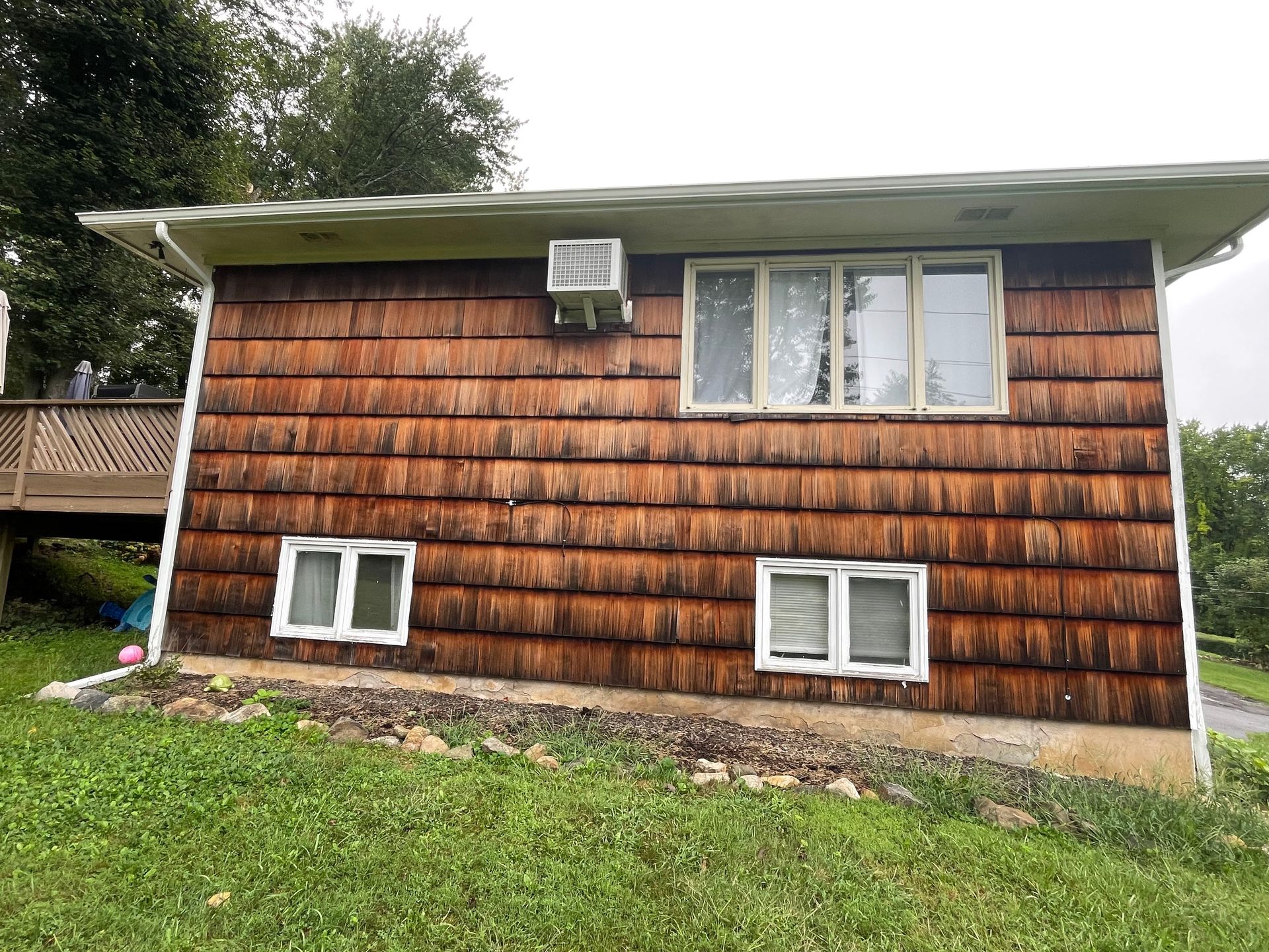 the side of a house with wooden siding and windows