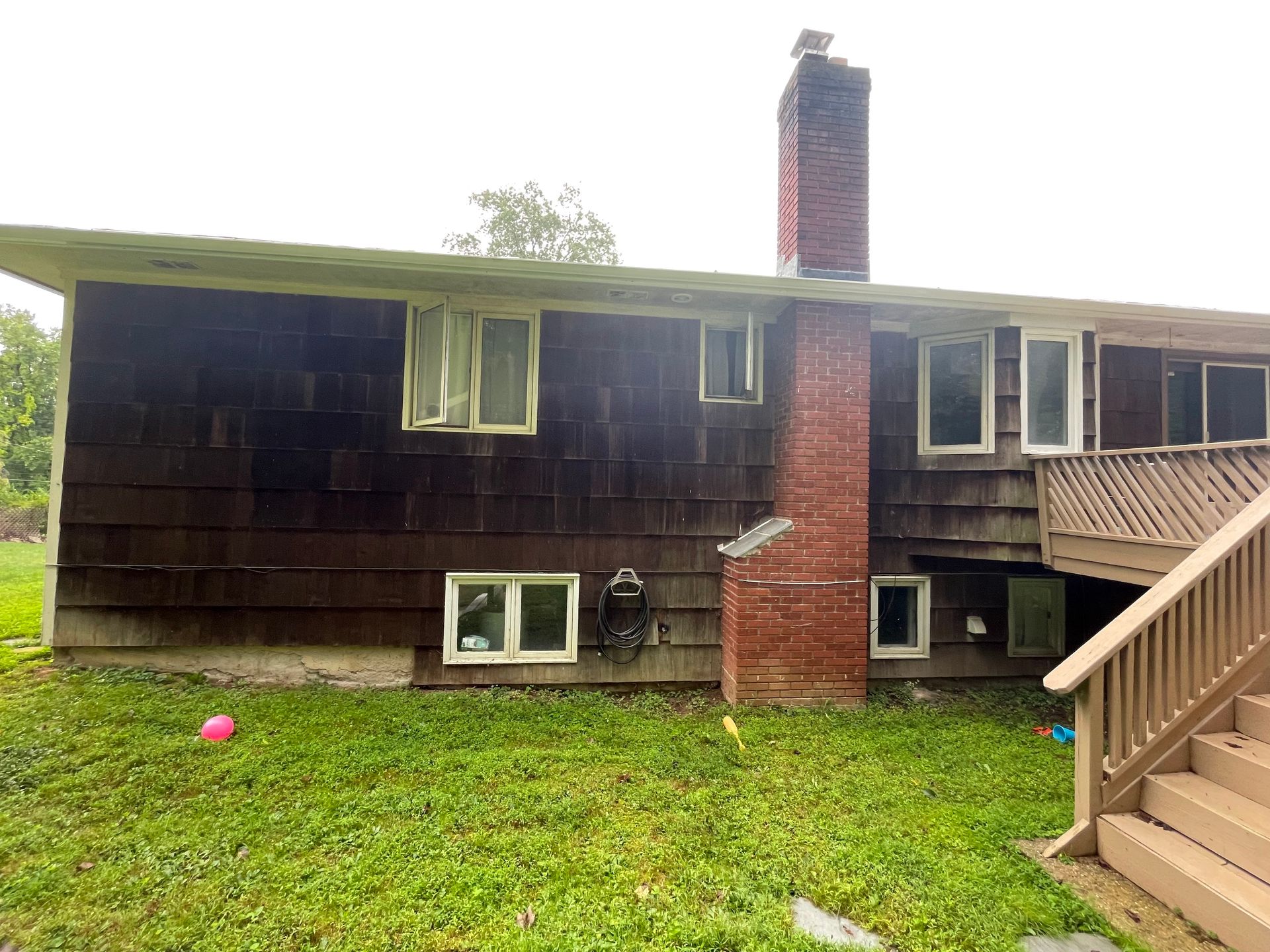the back of a house with a brick chimney and stairs