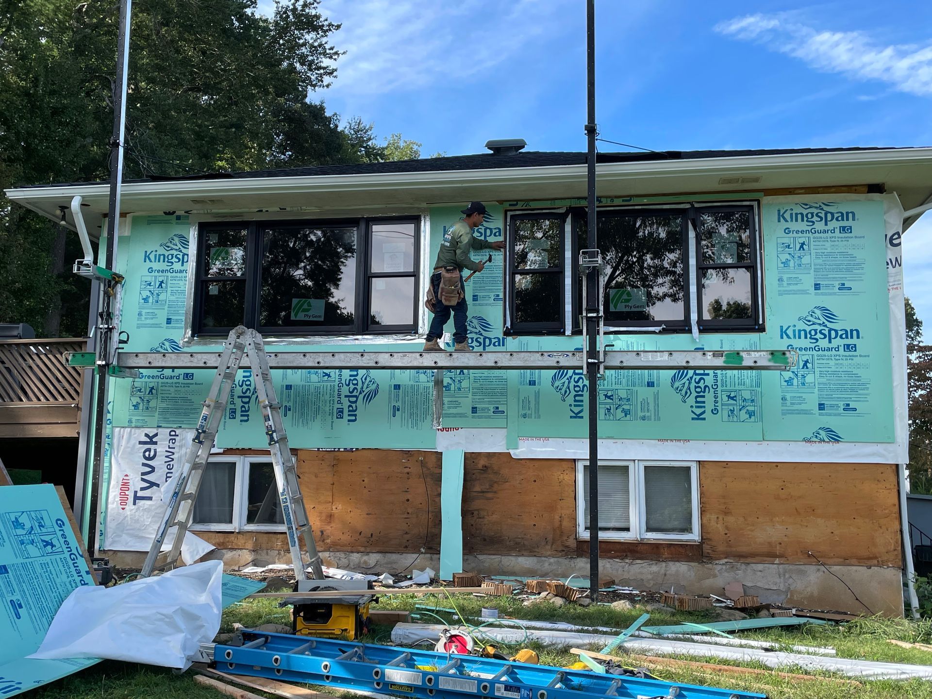 a man is standing on a ladder on the side of a house