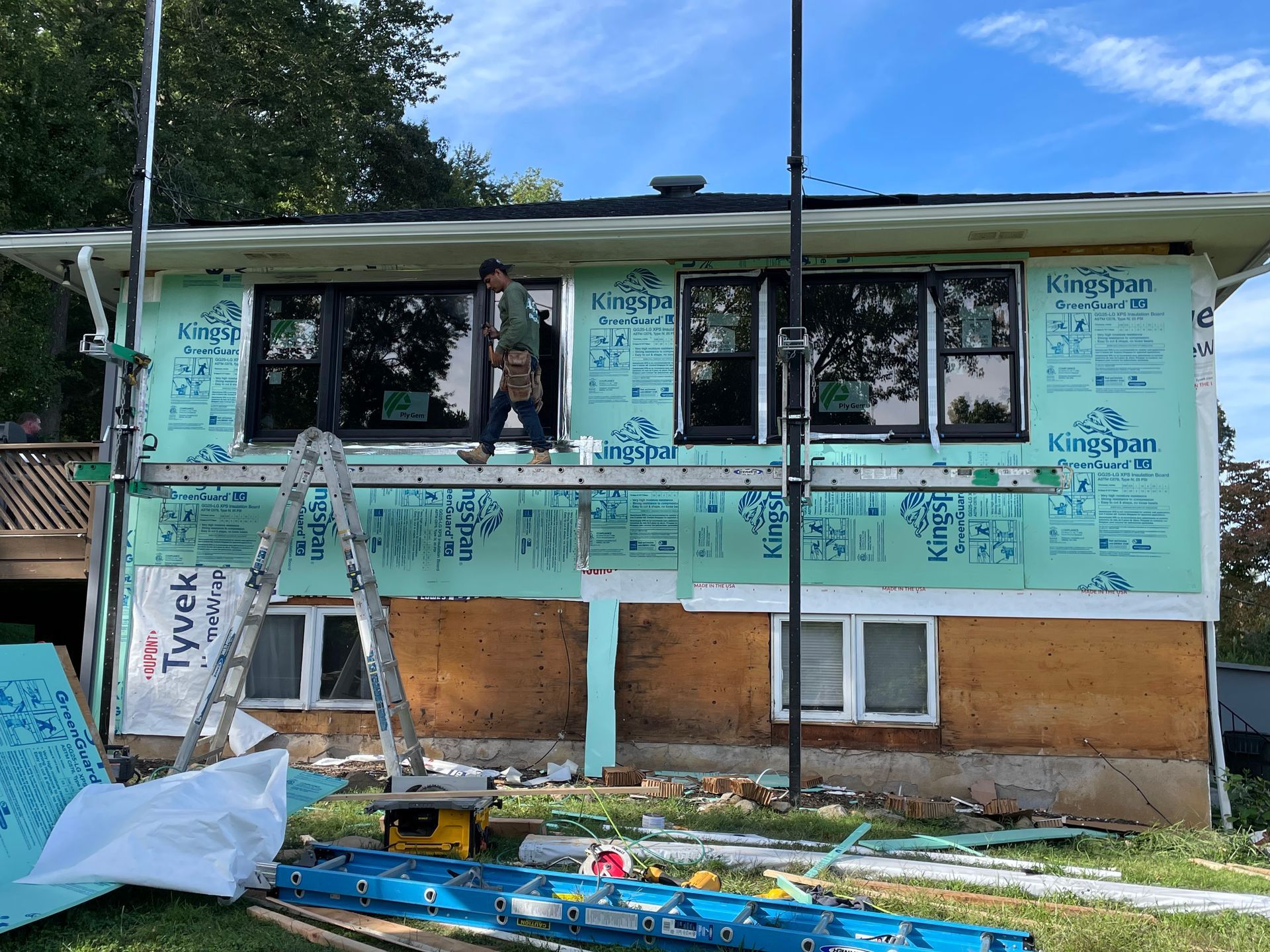 a man is working on the side of a house