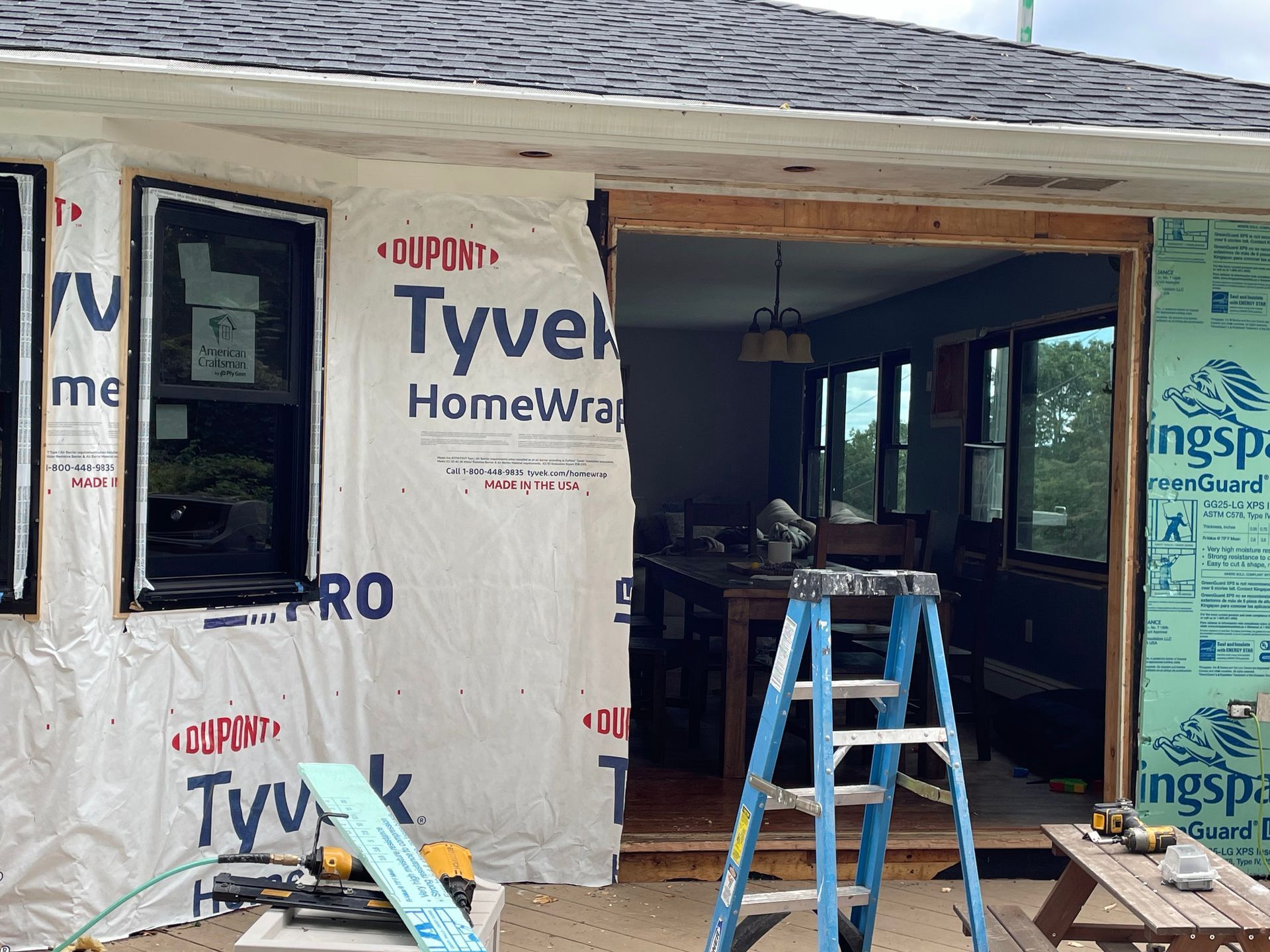 a ladder is sitting in front of a house that is being remodeled