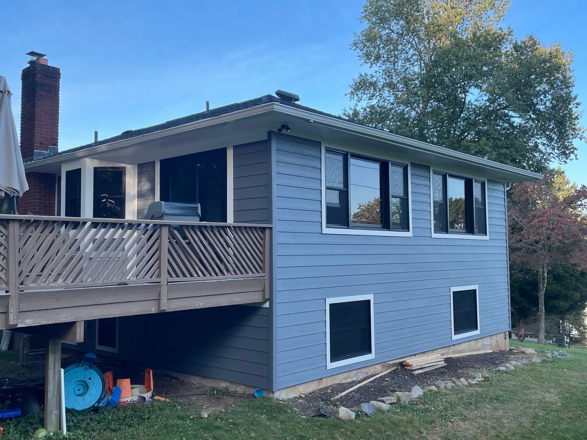 a blue house with a deck and a lot of windows