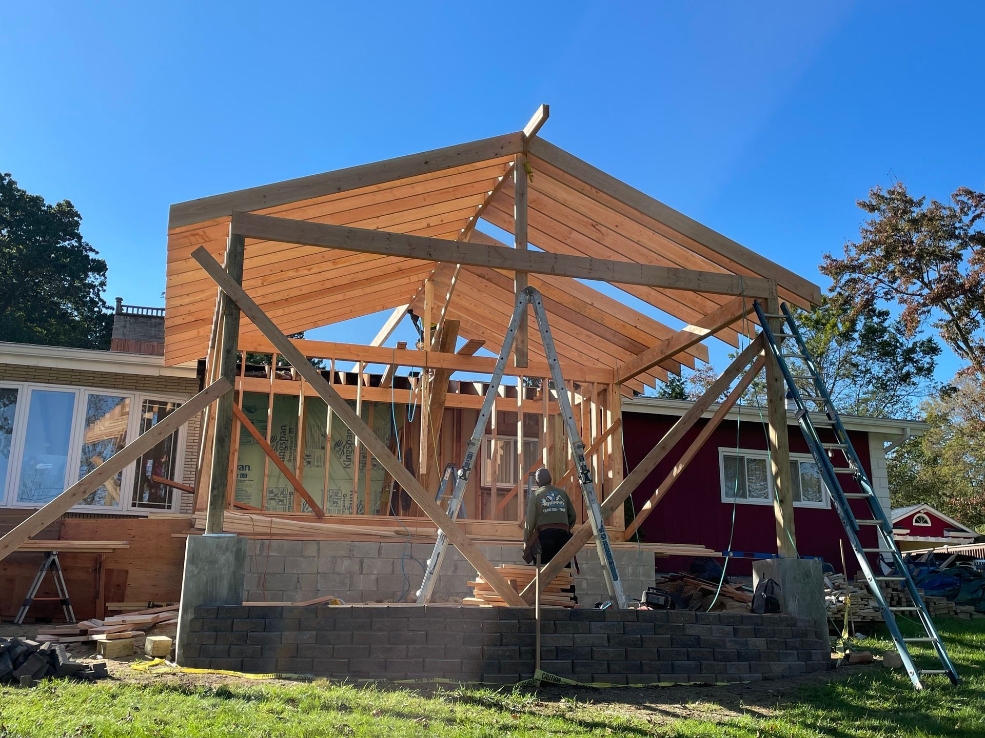 a wooden structure is being built in front of a red house