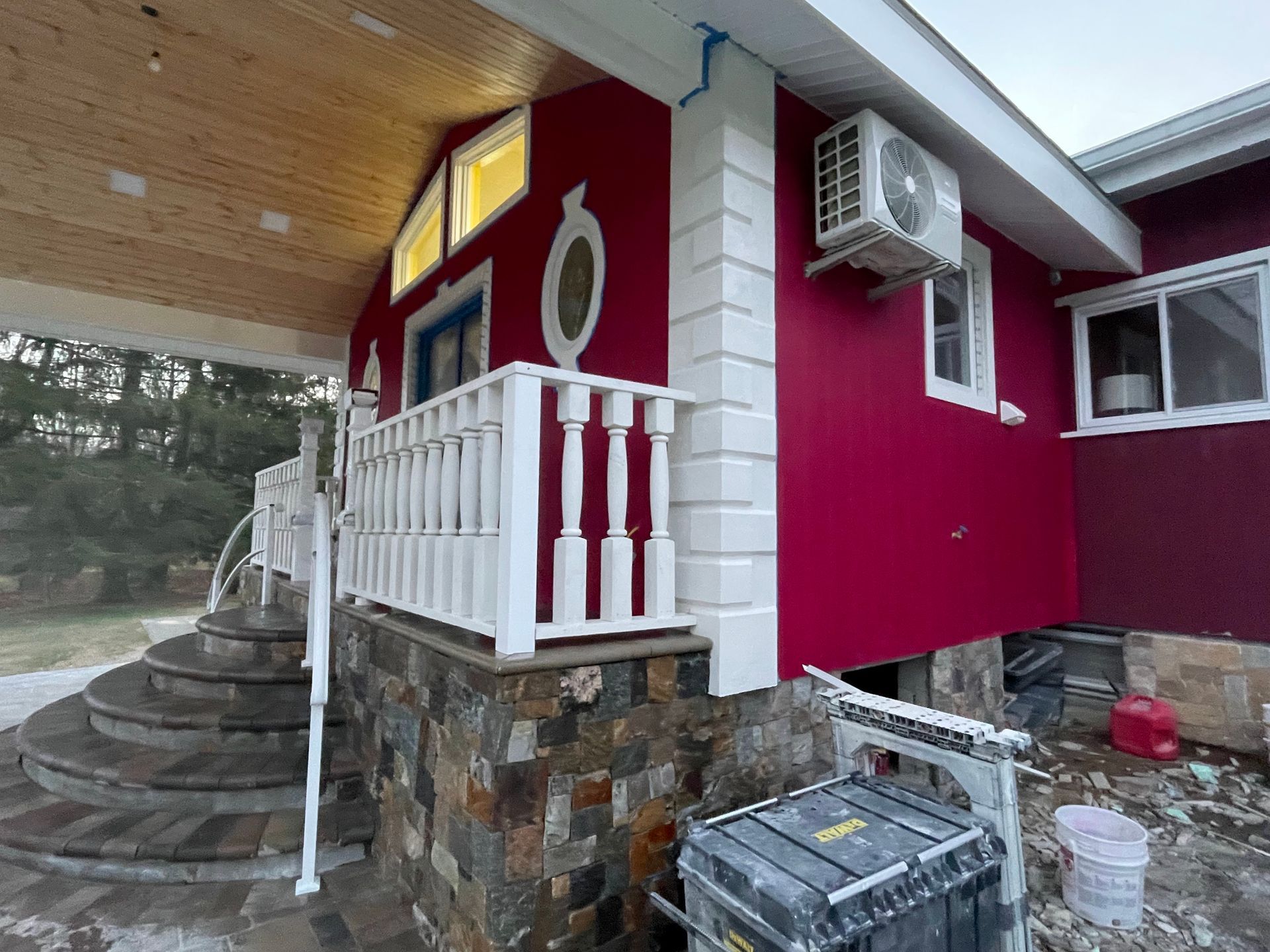 a red house with a white railing and stairs