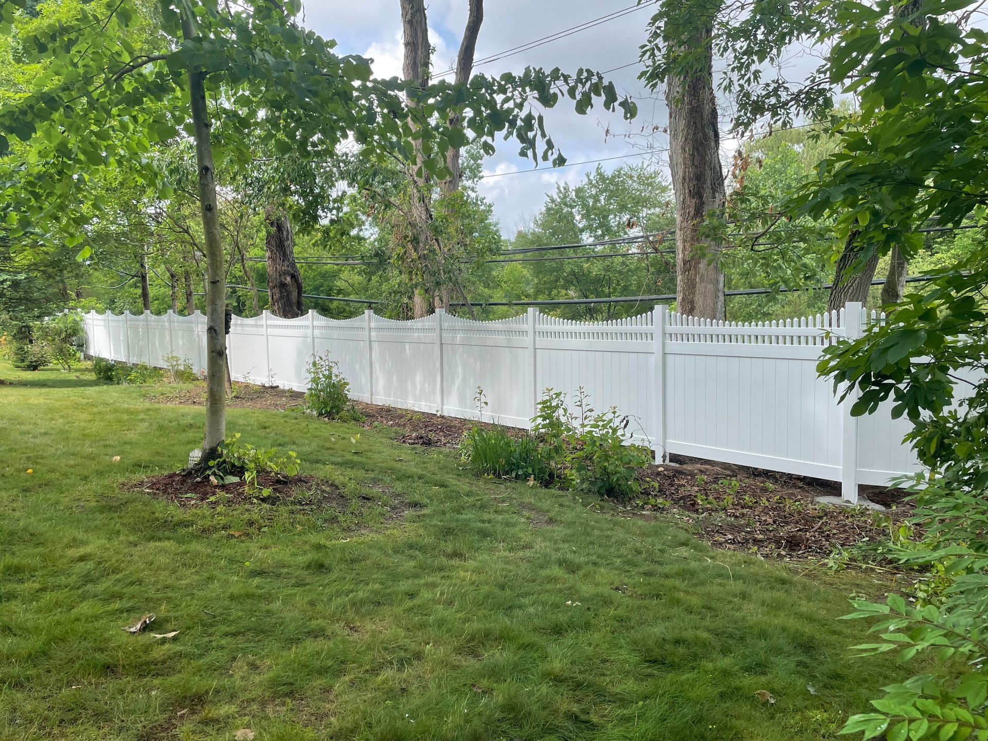 a white fence surrounds a lush green yard