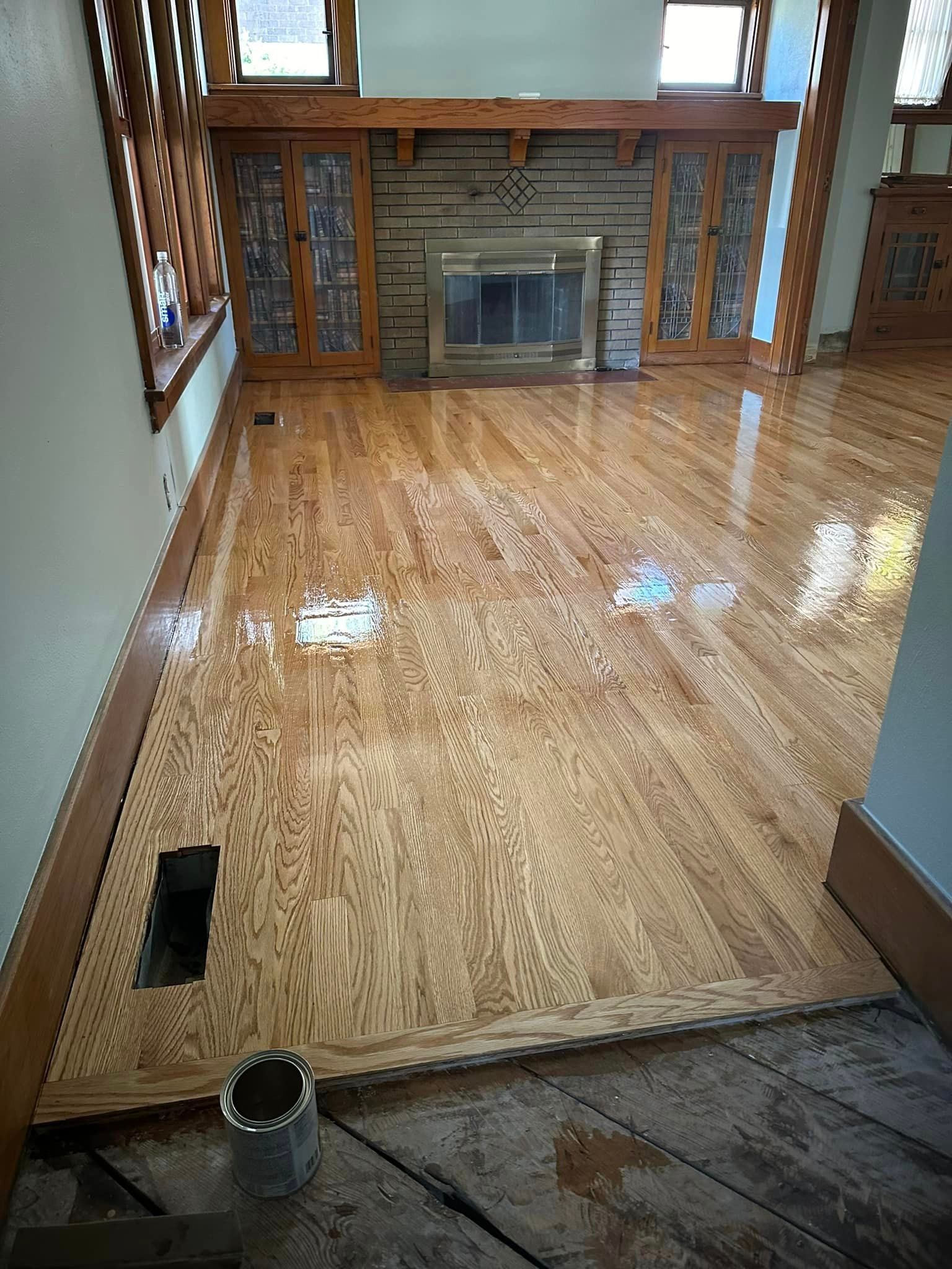 A living room with hardwood floors and a fireplace.