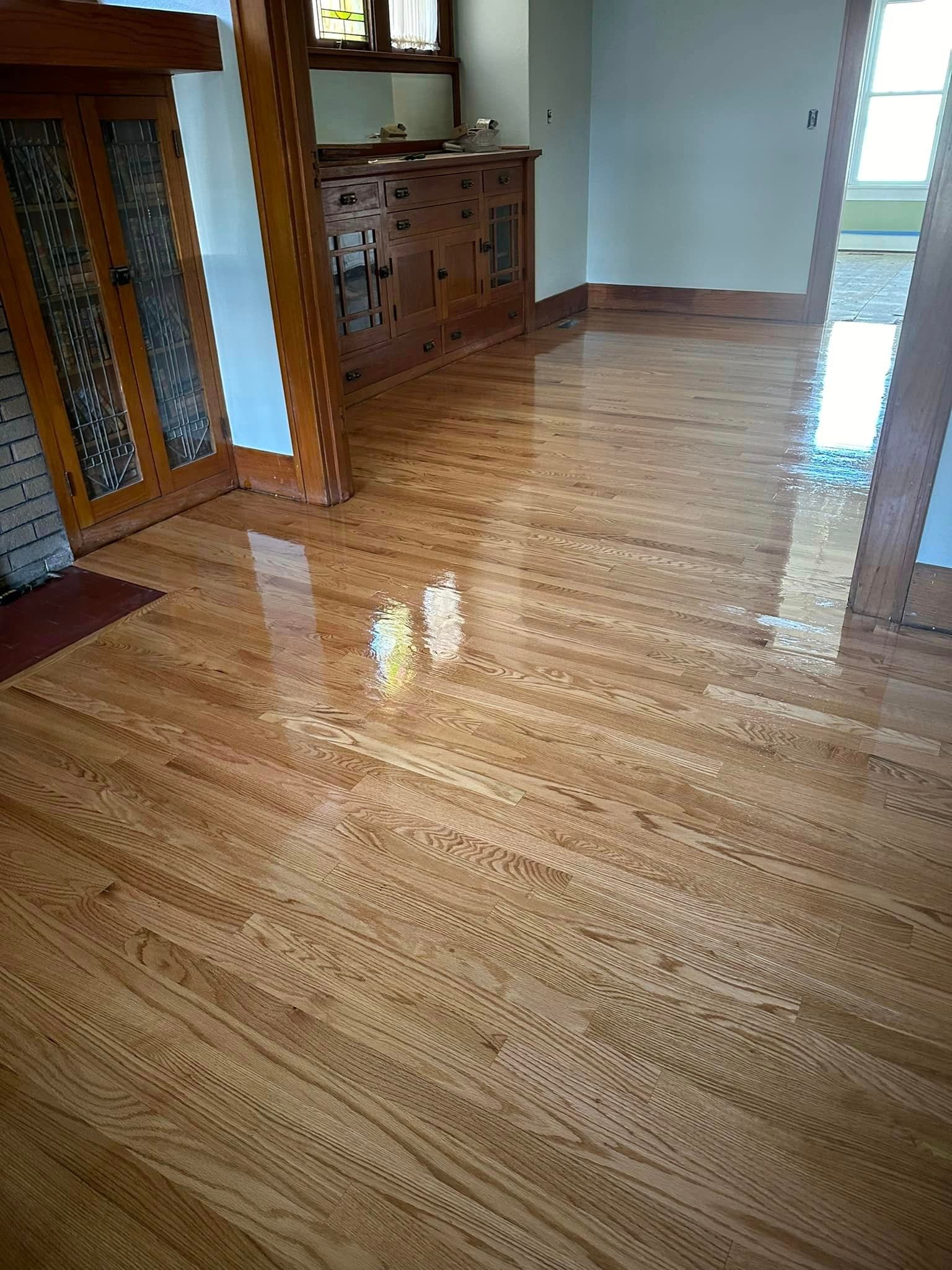 A living room with hardwood floors and a stained glass door.