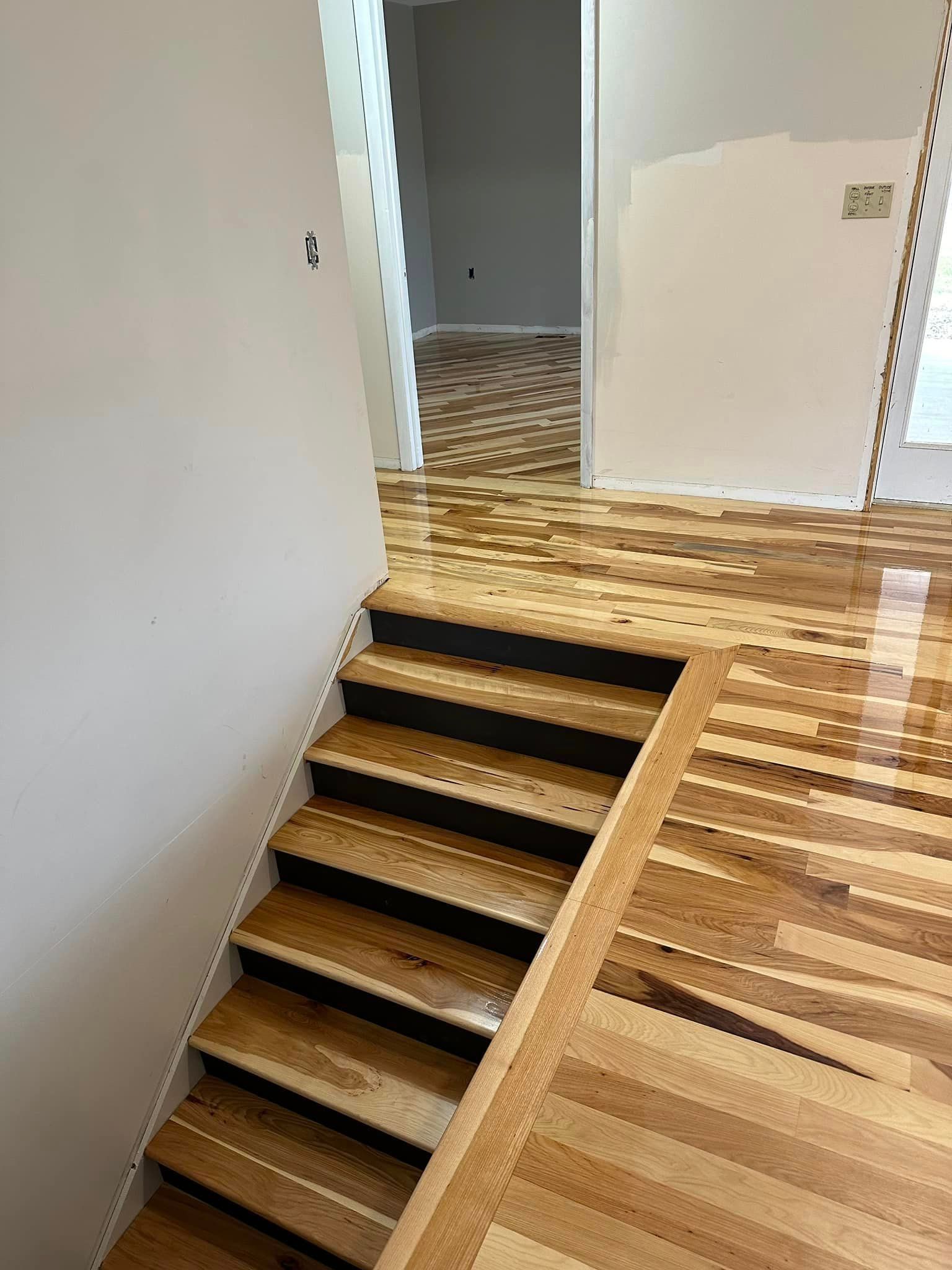 A set of wooden stairs leading up to a wooden floor in a house.