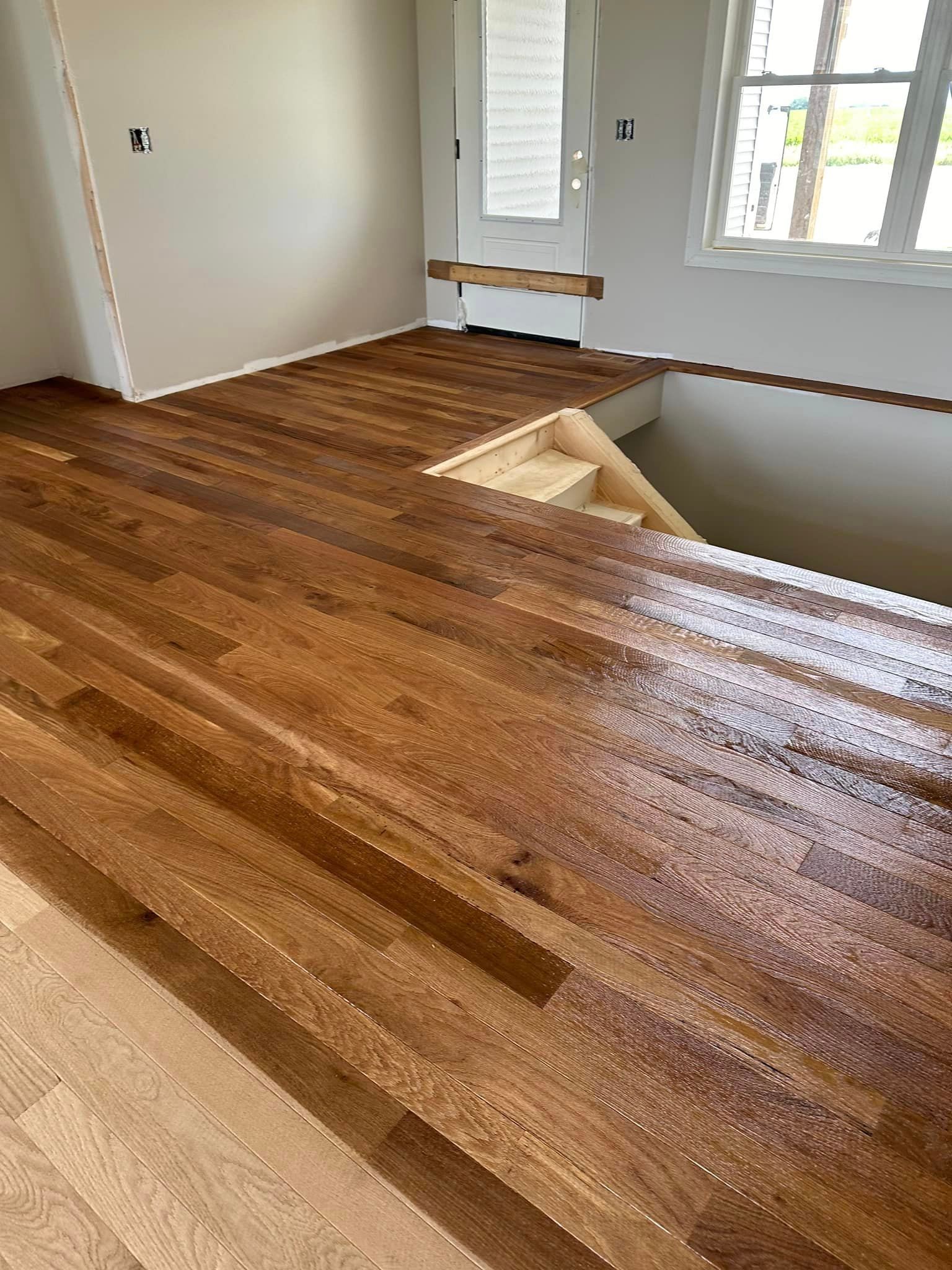 A room with a wooden floor and stairs in it.