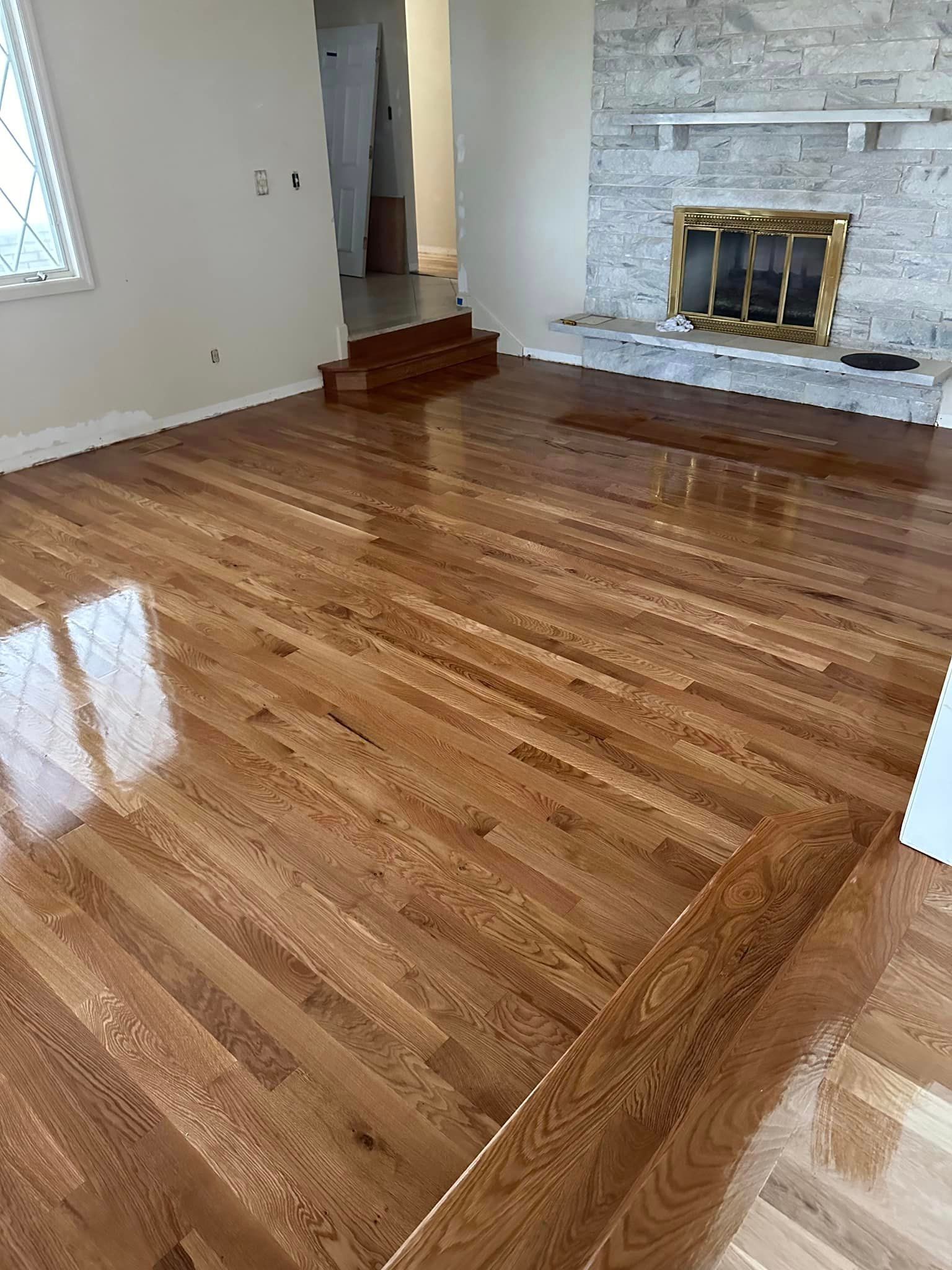 A living room with hardwood floors and a fireplace.