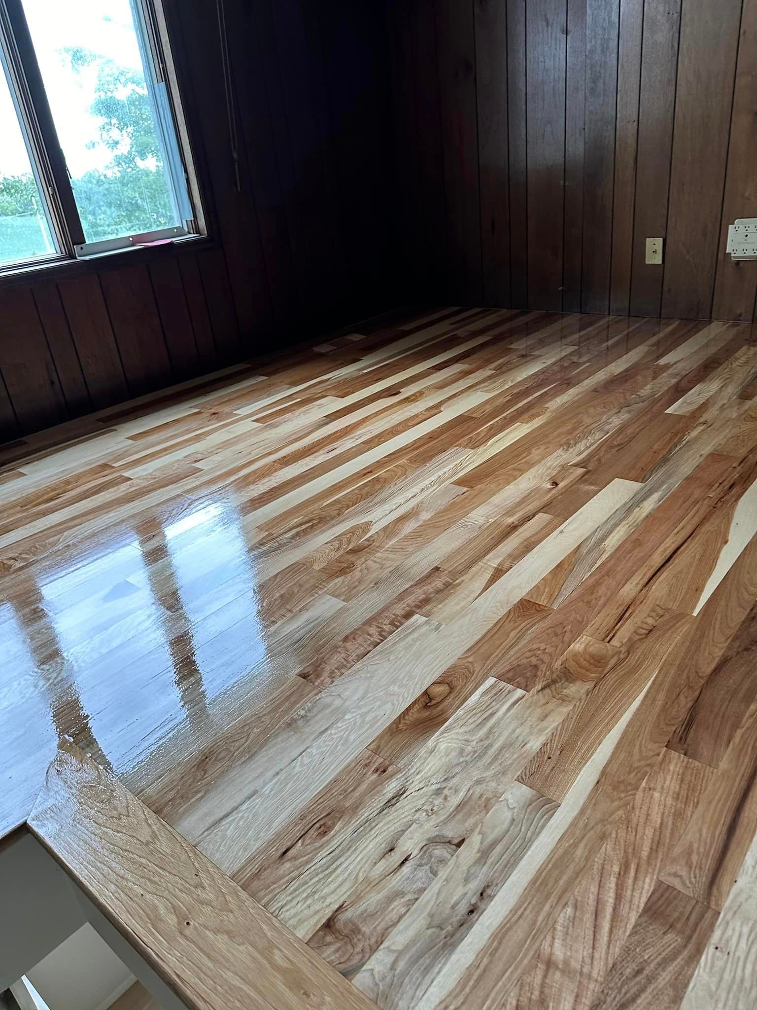 A room with a wooden floor and a window.