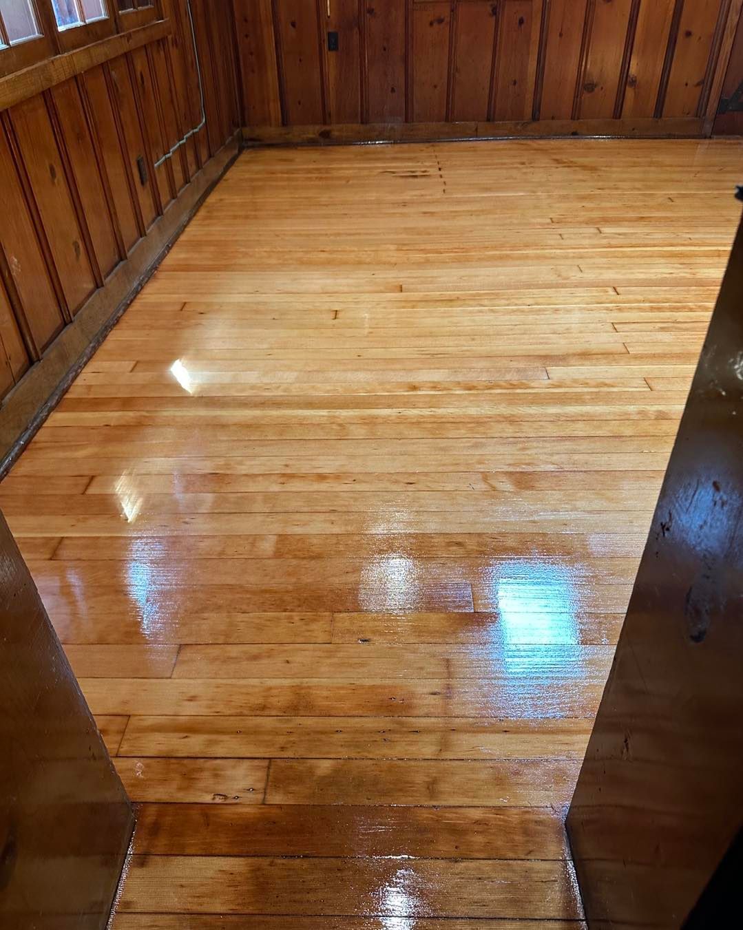 A wooden floor in a room with wooden walls.