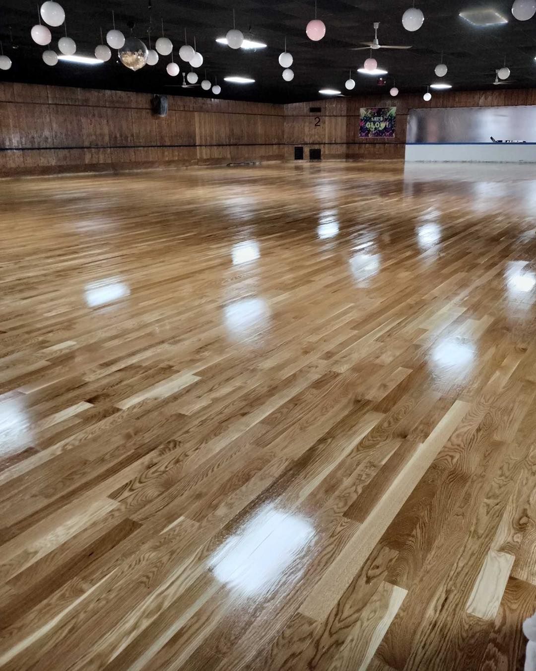 A large empty dance studio with a wooden floor.