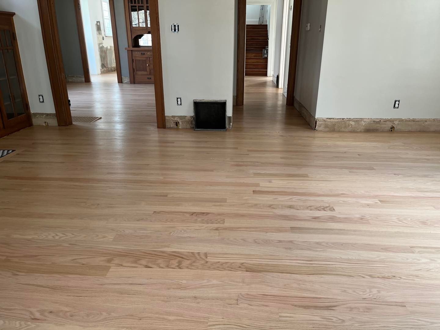 A living room with hardwood floors and white walls.