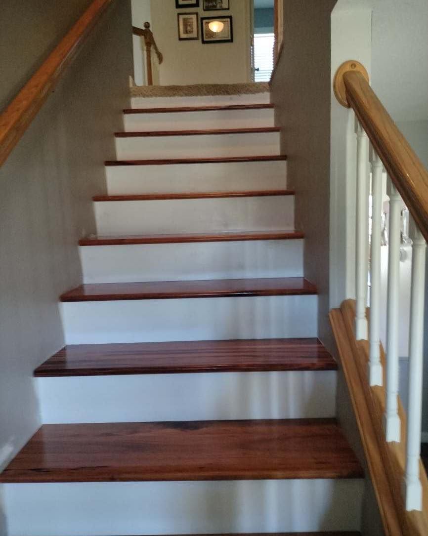 A set of stairs with wooden steps and a white railing