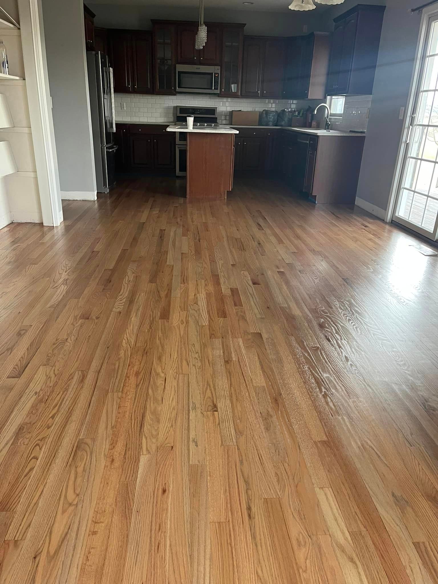 A kitchen with hardwood floors and a large island in the middle of the room.