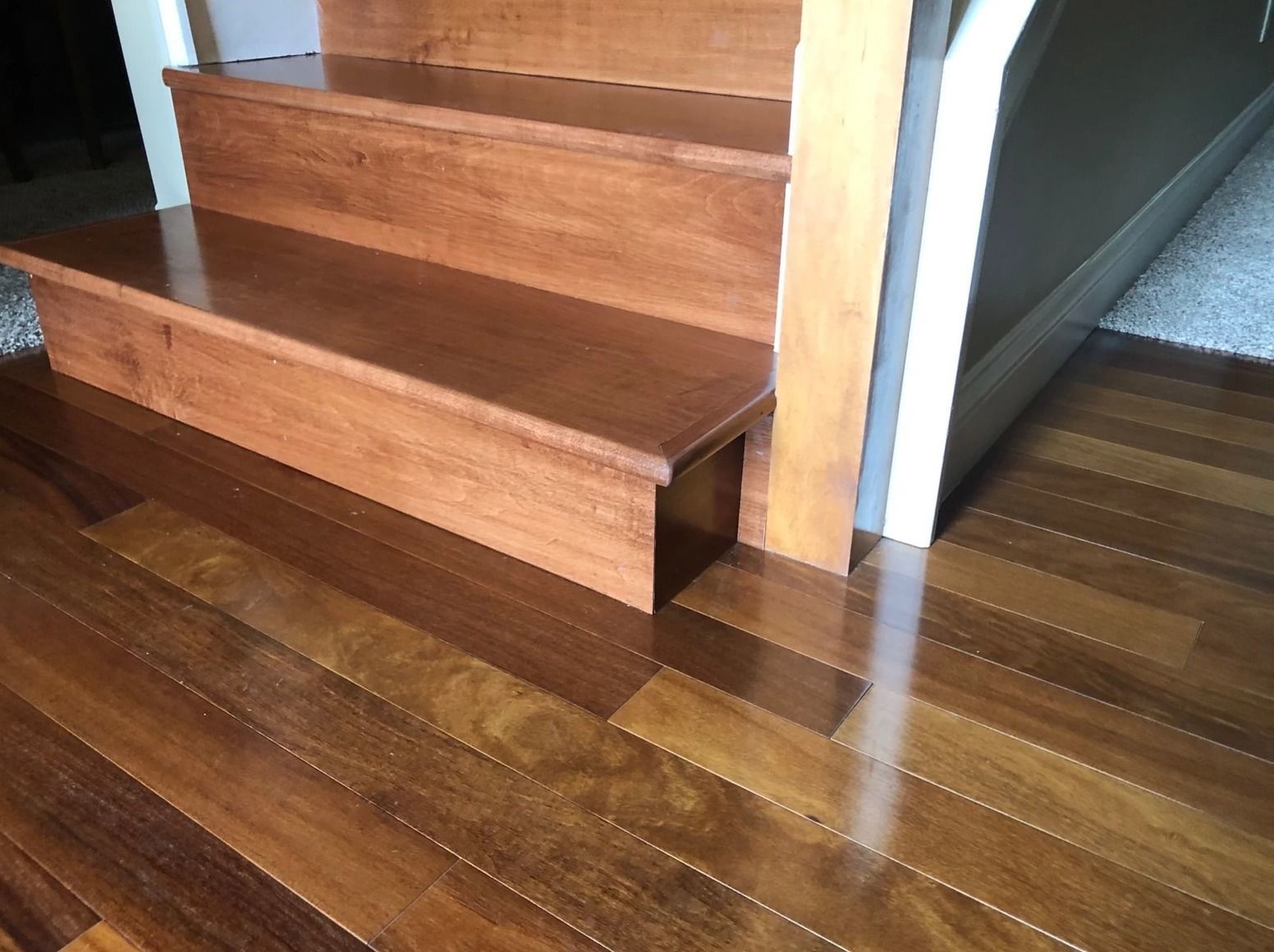 A close up of a wooden staircase with a wooden floor.