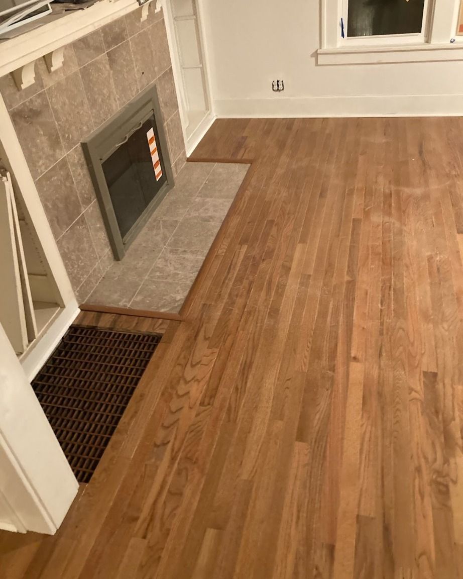 A living room with hardwood floors and a fireplace.