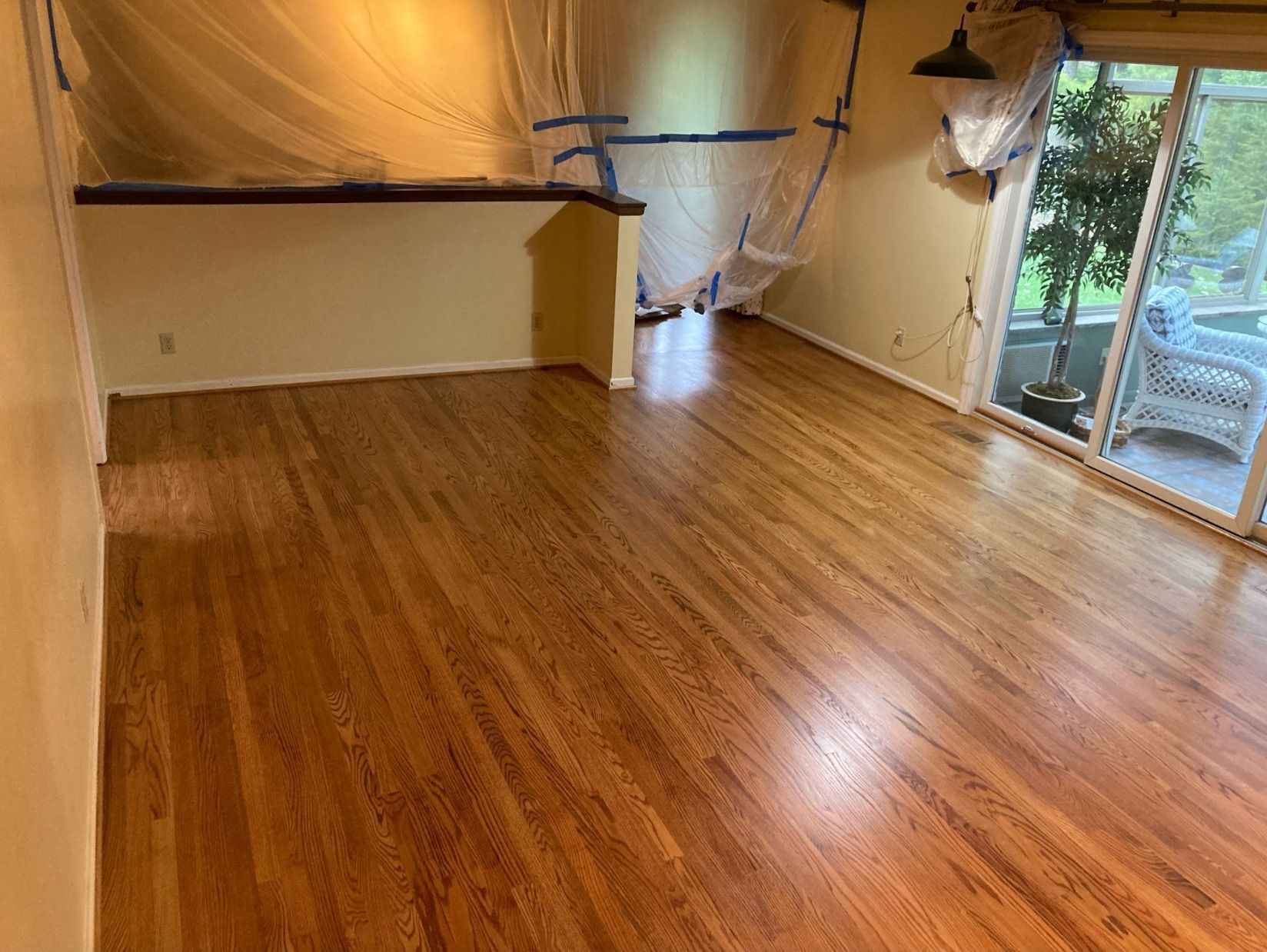 A living room with hardwood floors and a sliding glass door.