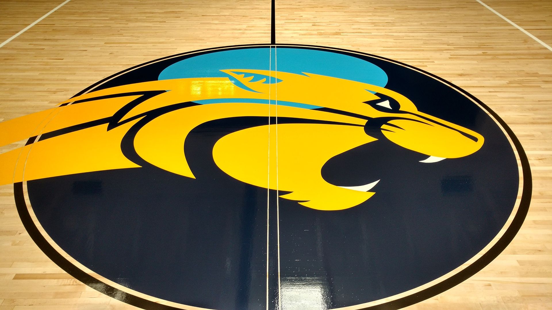 A yellow and blue logo on a basketball court