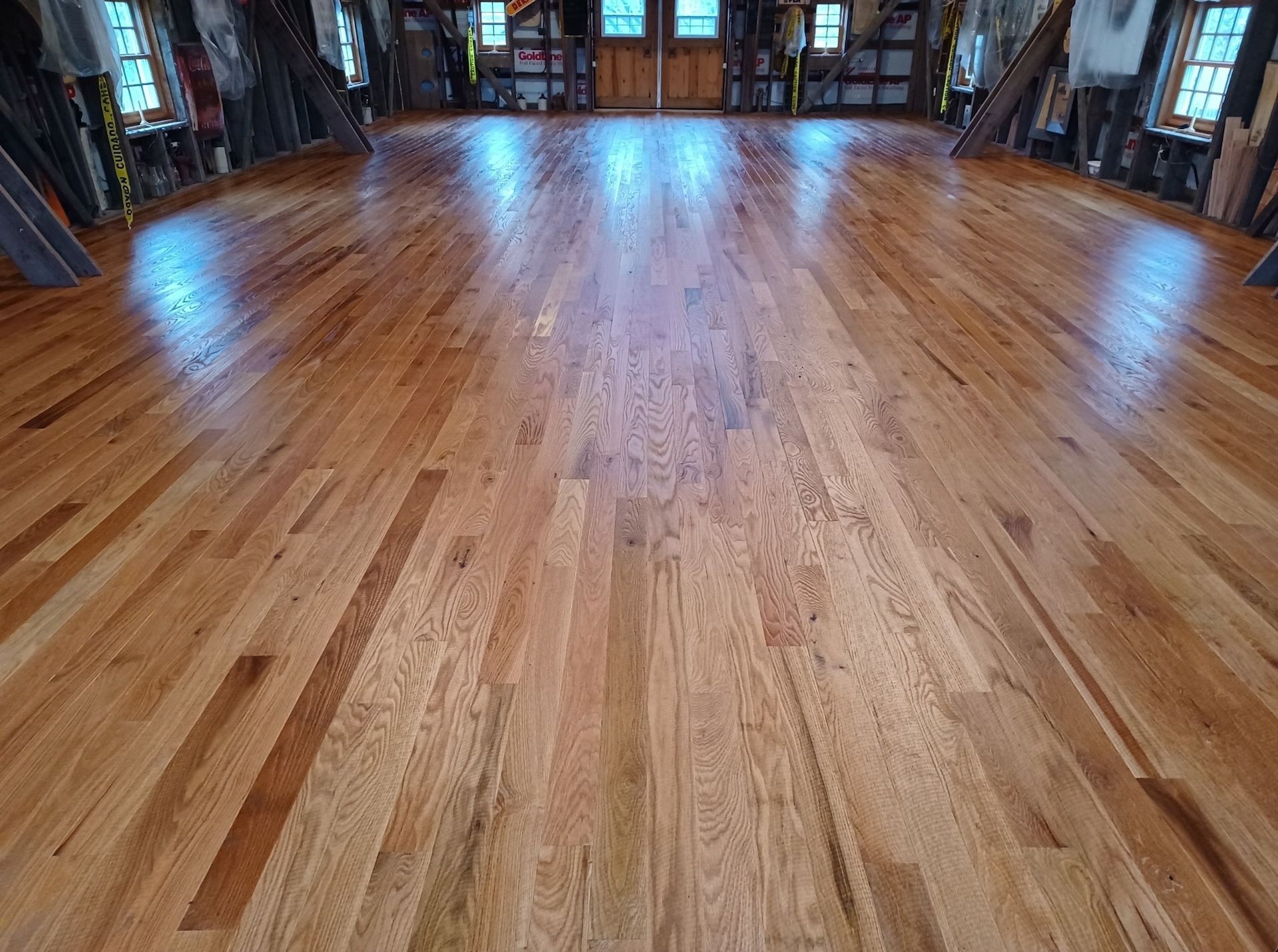 A large room with a wooden floor and a lot of windows.