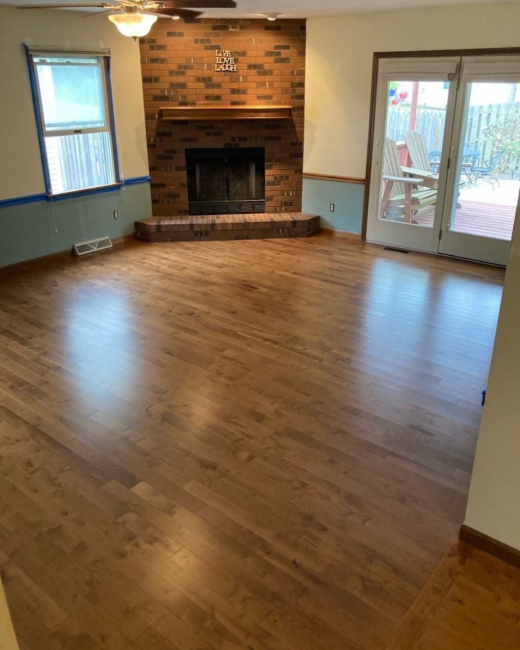 An empty living room with hardwood floors and a fireplace.