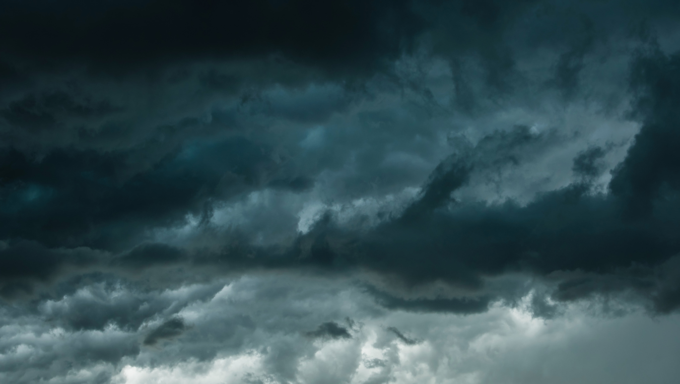 Dark storm clouds fill the sky above a faint, cloudy horizon.