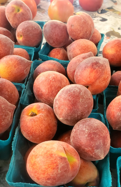 A bunch of peaches in blue baskets on a table