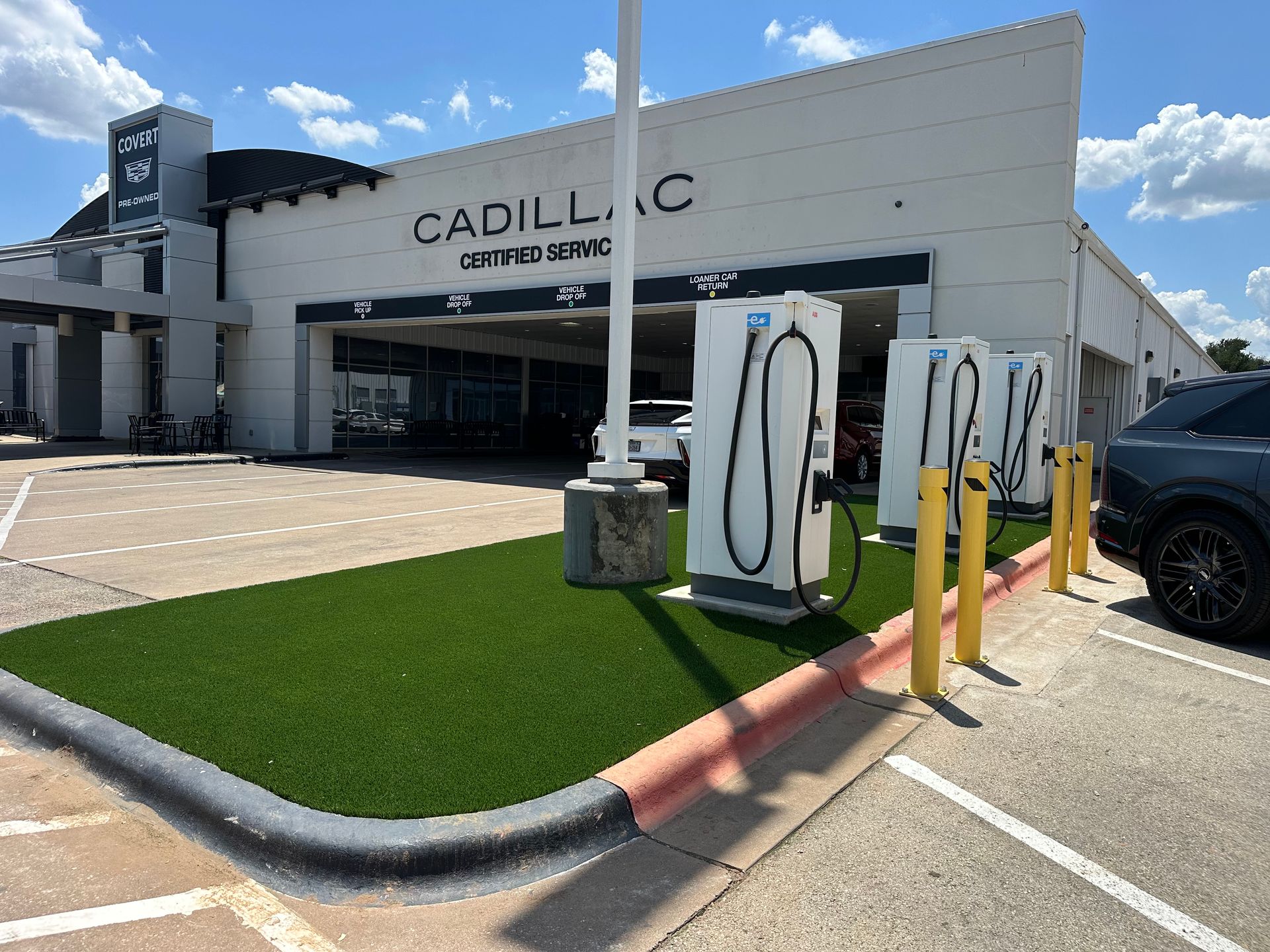 Cadillac dealership with EV chargers. Building has 
