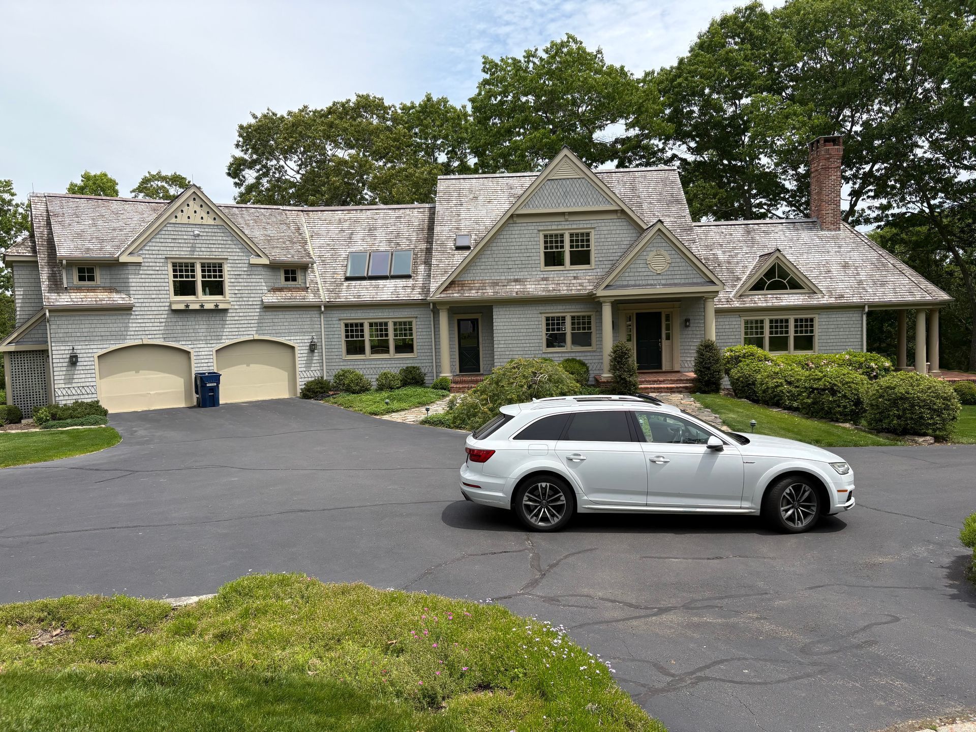 Large gray house with a two-car garage and a white SUV parked in the driveway
