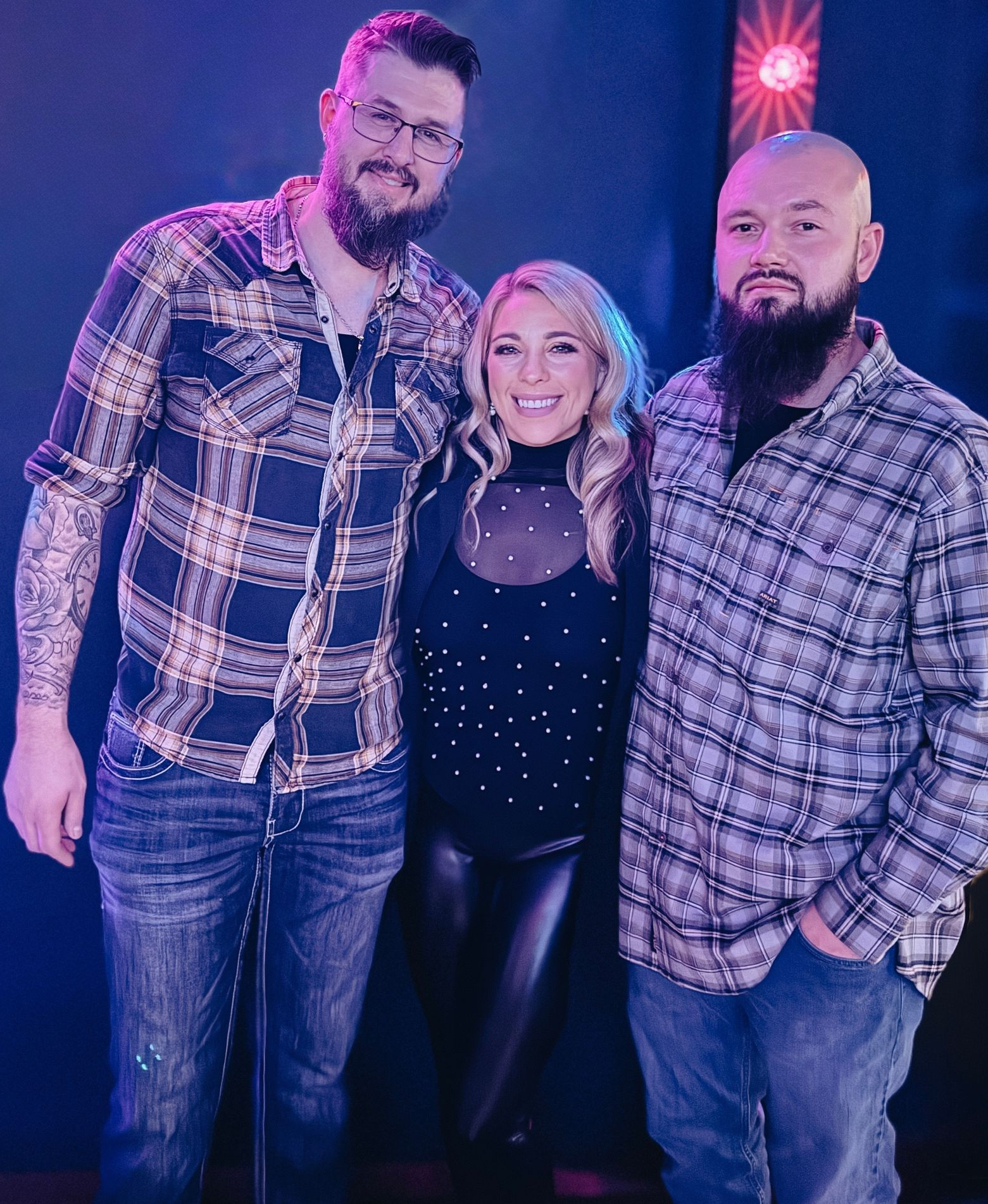 A hand adjusting the thermostat of an electric water heater mounted on a white tiled wall.