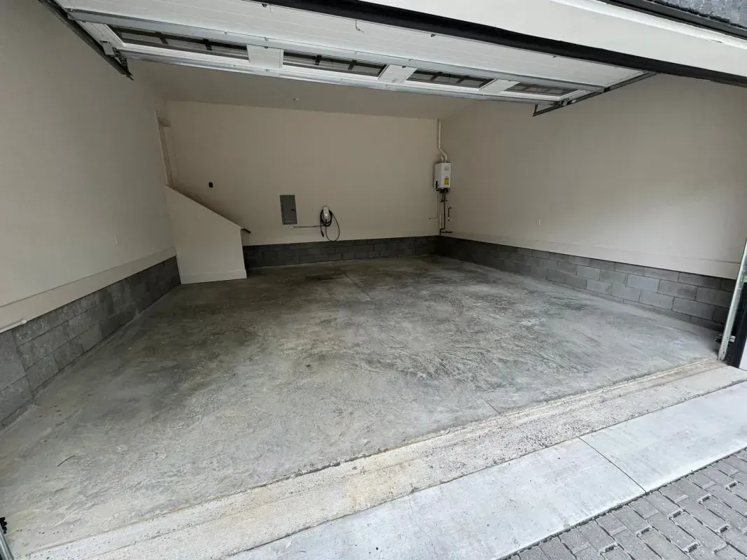 Empty single-car garage with concrete floor and open overhead door